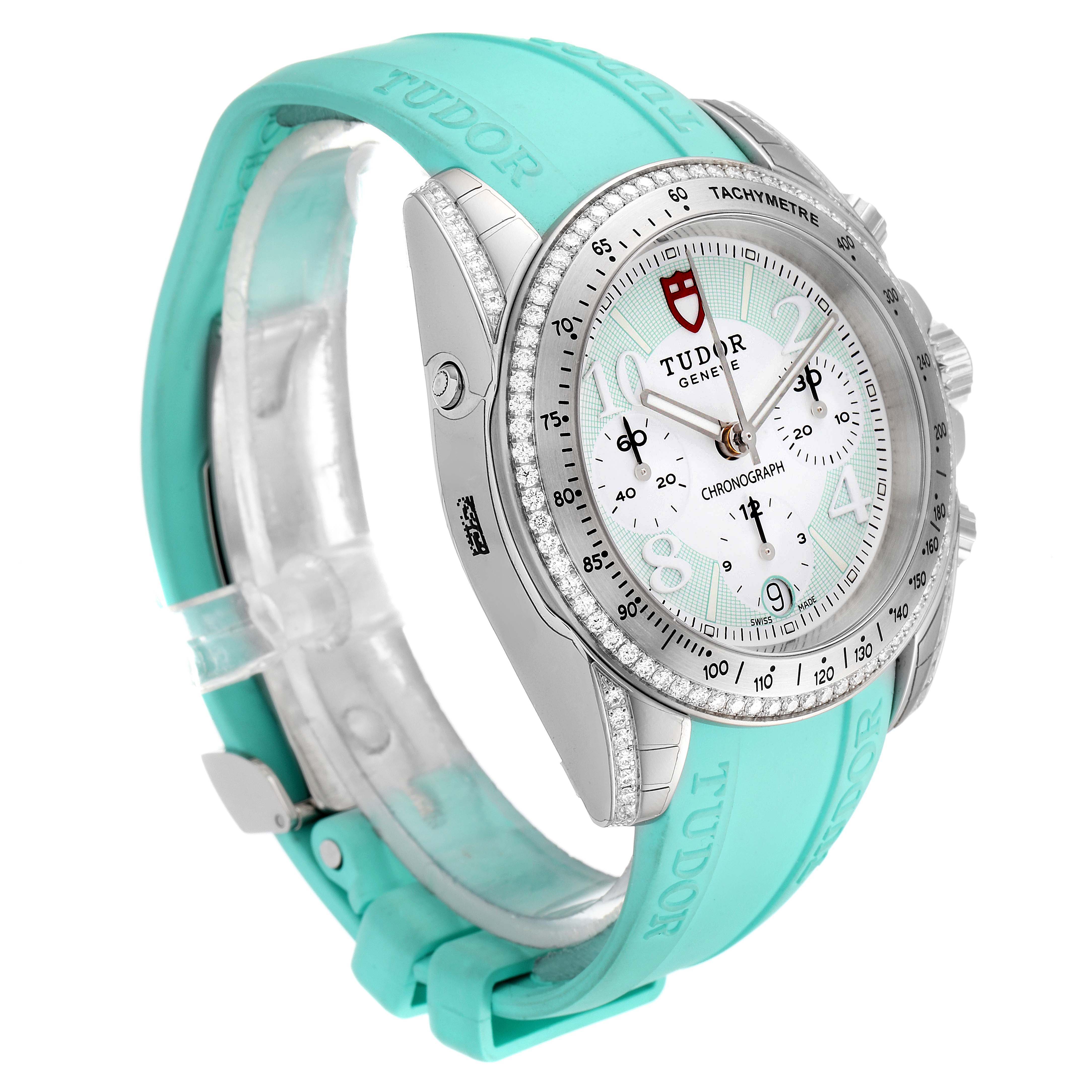 The image shows a Tudor Grantour 20310 Men
s Stainless Steel White Dial 20310 Men
s Stainless Steel White Dial watch from a side angle, highlighting the face, bezel, and turquoise strap.