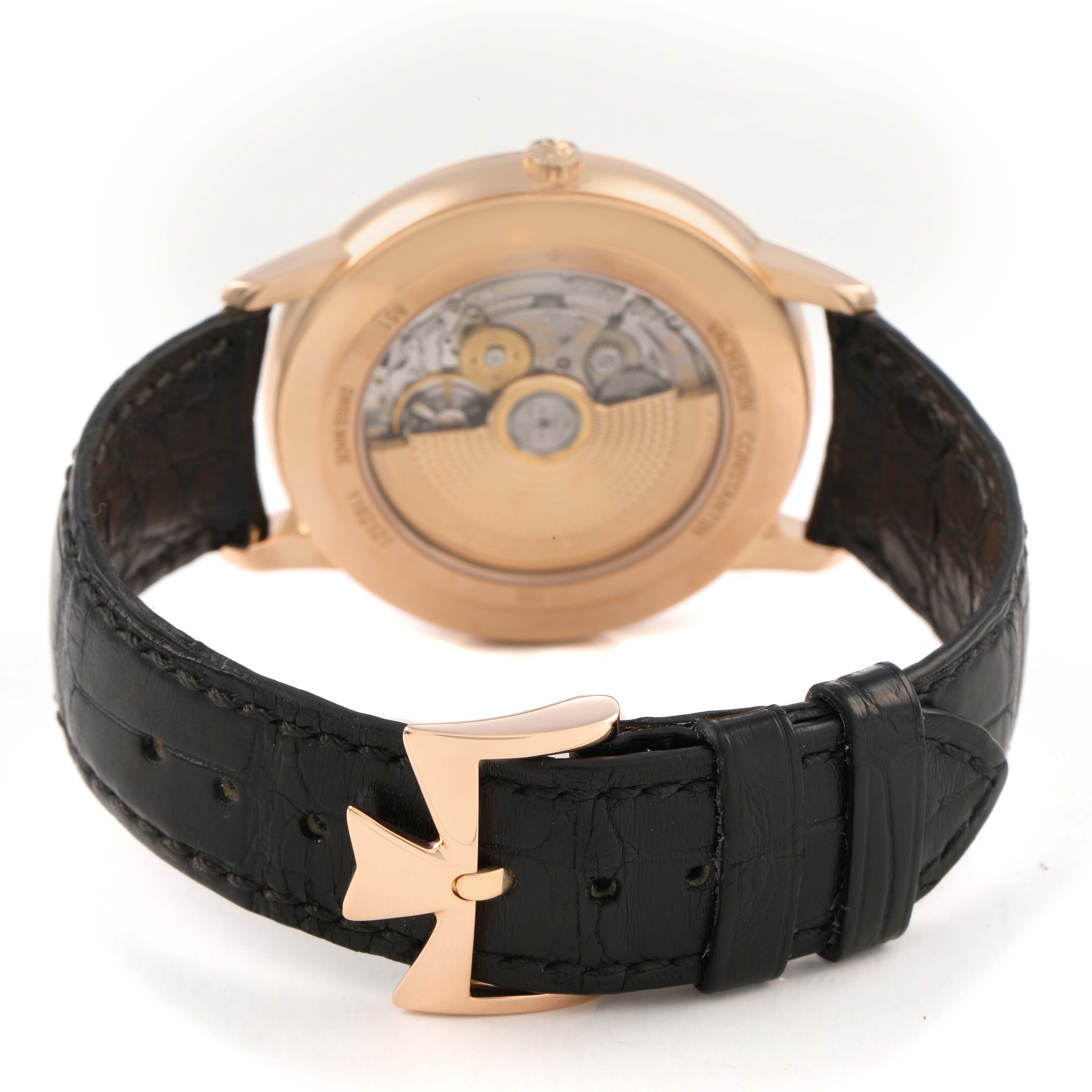 The image shows the back of the Vacheron Constantin Patrimony 85180/000R-9232 Men's Rose Gold Black Dial watch, highlighting its movement and black leather strap.