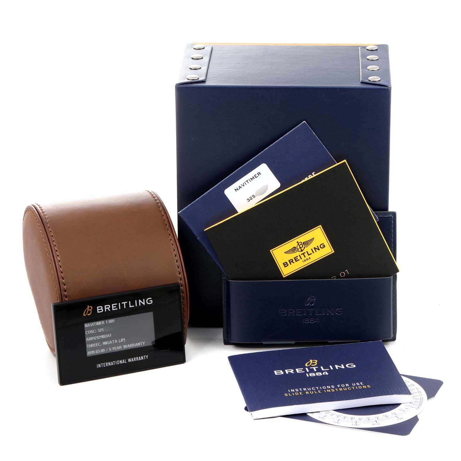The image shows the Breitling Navitimer AB0121 Men
s Stainless Steel Black Dial AB0121 Men
s Stainless Steel Black Dial
s packaging, instructions, warranty card, and a brown leather watch case from a front angle.
