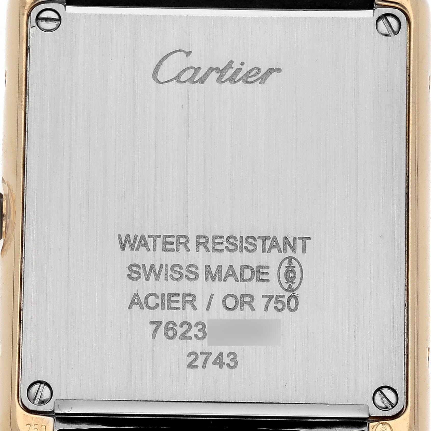 The image shows the back case of a Cartier Tank Solo W1018755 Women
s Steel and Gold (two tone) Silver Dial W1018755 Women
s Steel and Gold (two tone) Silver Dial watch, highlighting its engraved details and screws.