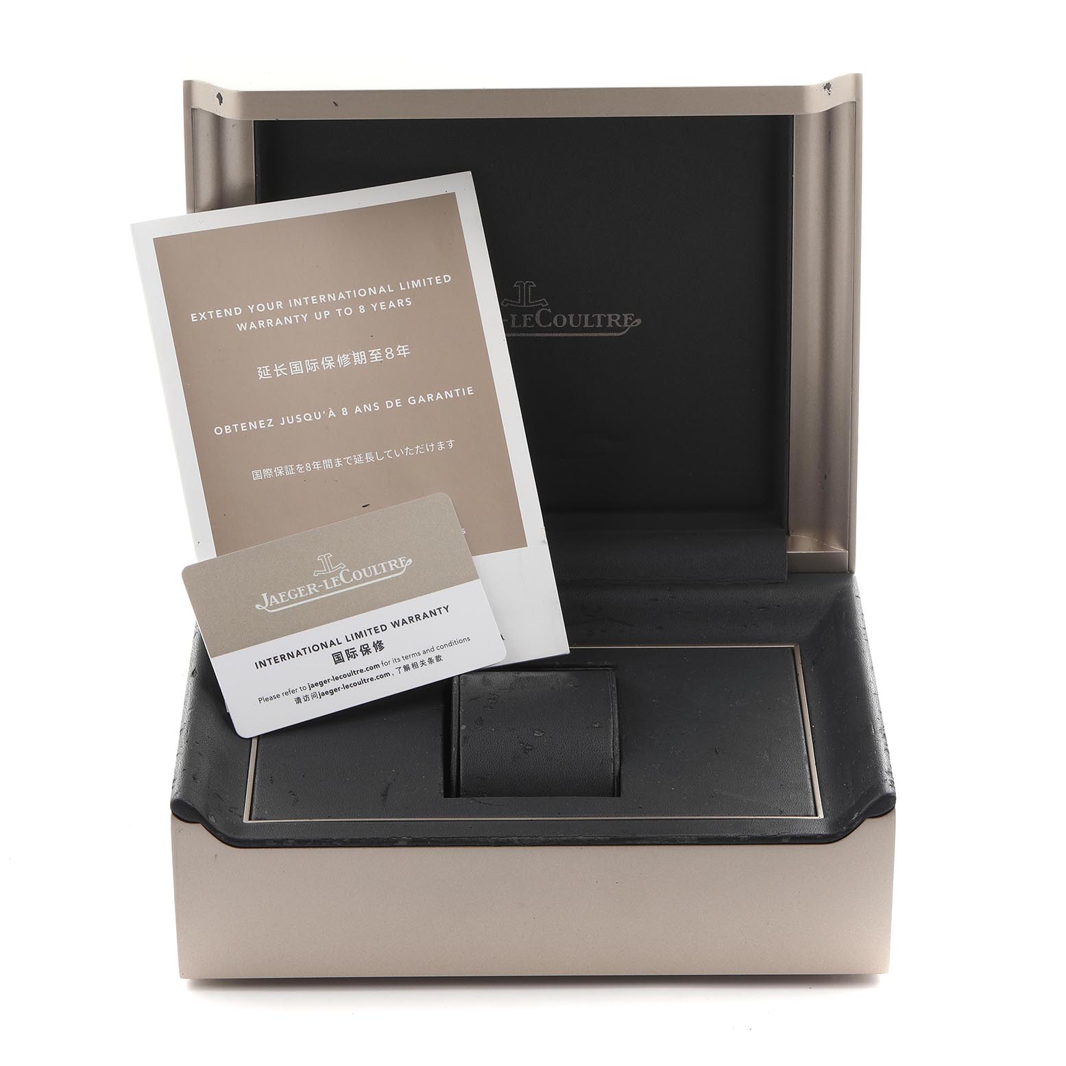 The image shows an open Jaeger-LeCoultre Reverso watch box with warranty cards, viewed from the front.