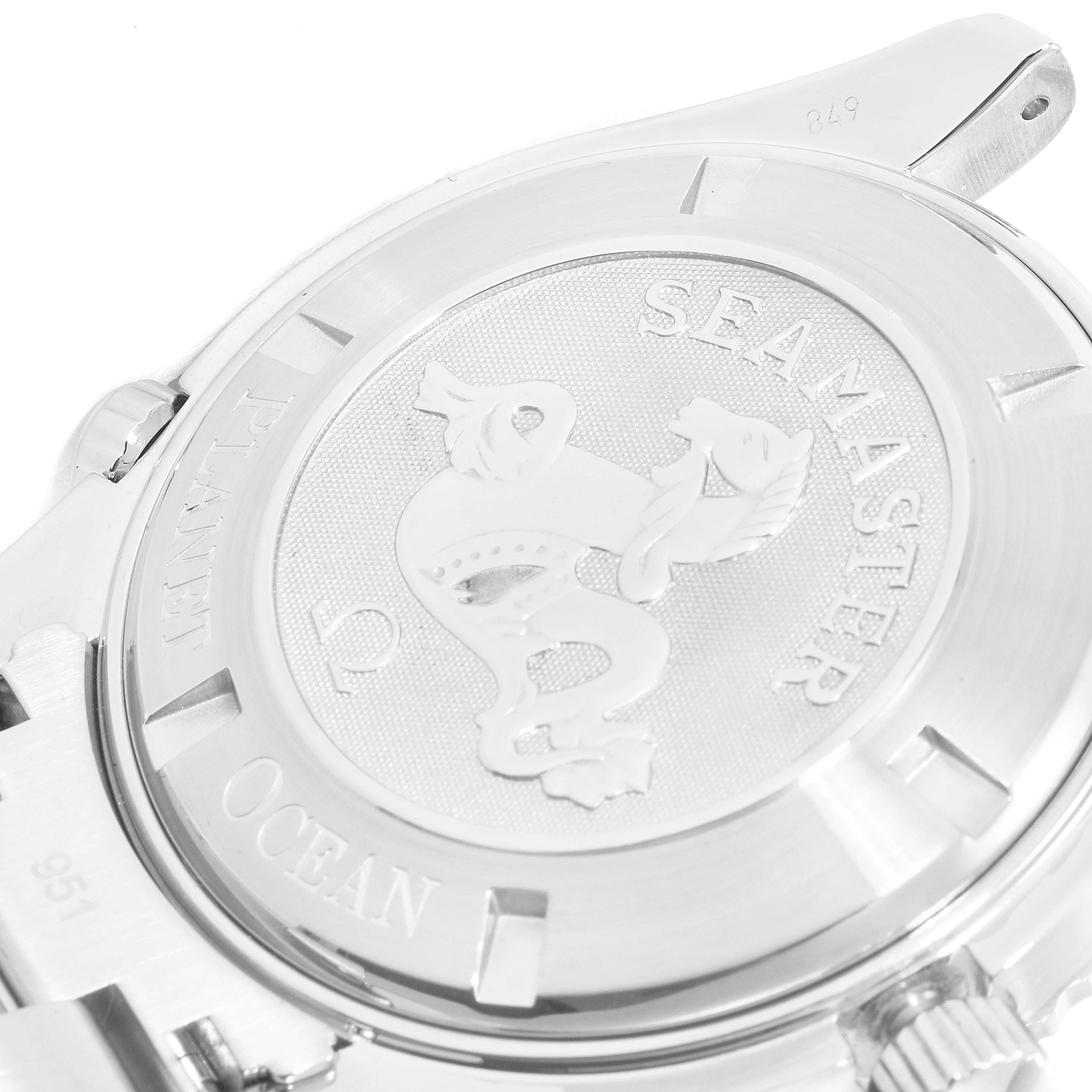 The image shows the back of the Omega Planet Ocean 2200.50.00 Men
s Stainless Steel Black Dial 2200.50.00 Men
s Stainless Steel Black Dial watch from a close-up angle, highlighting the engraved Seahorse emblem and the words "Seamaster" and "Ocean."