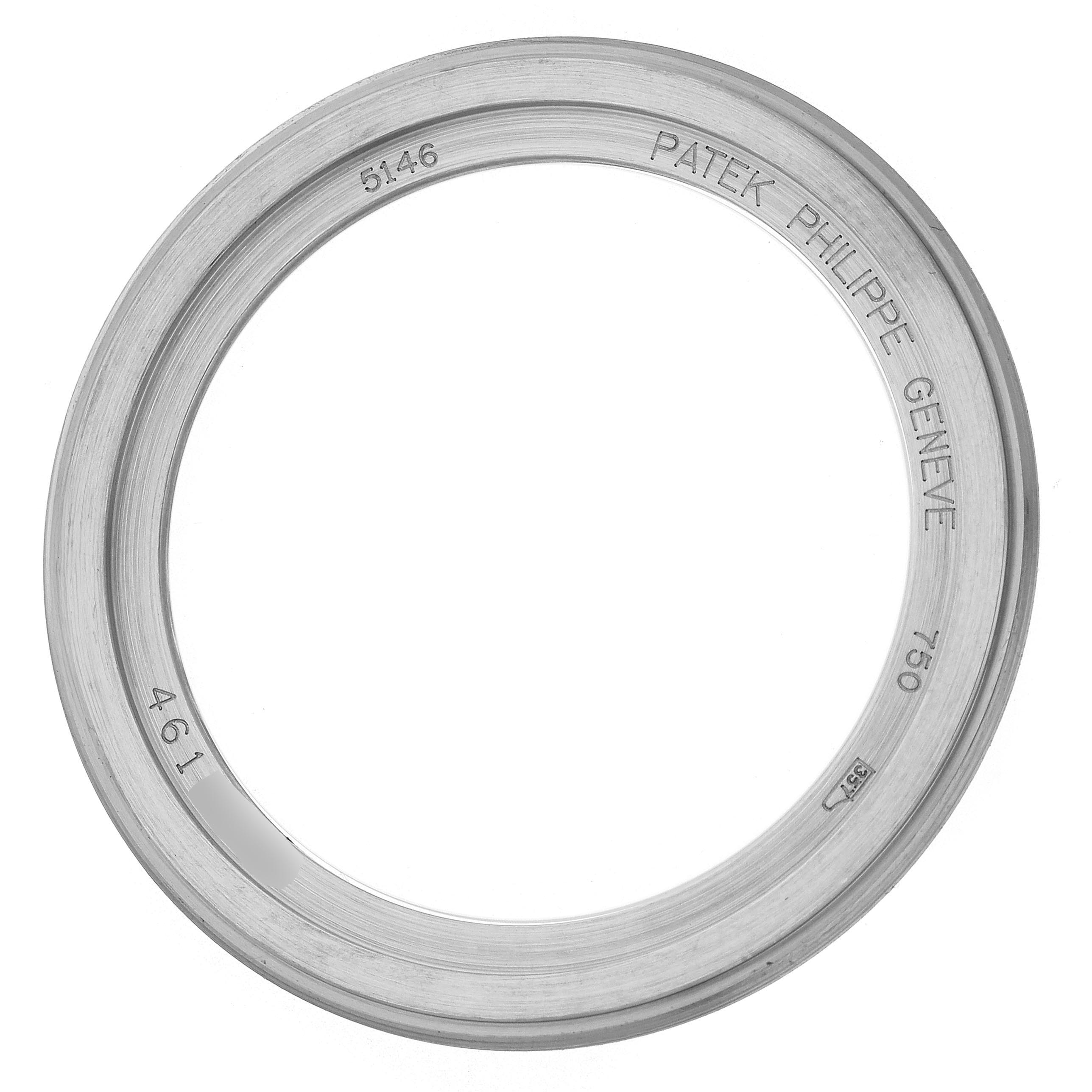 The image shows the bezel of a Patek Philippe Complications 5146G-010 Men
s White Gold Grey Dial 5146G-010 Men
s White Gold Grey Dial watch with engravings, viewed from above.