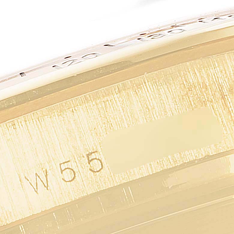 This close-up image shows part of the bezel and case with engravings on a Rolex Daytona 16528 Men's Yellow Gold Black Dial 16528 Men's Yellow Gold Black Dial watch.