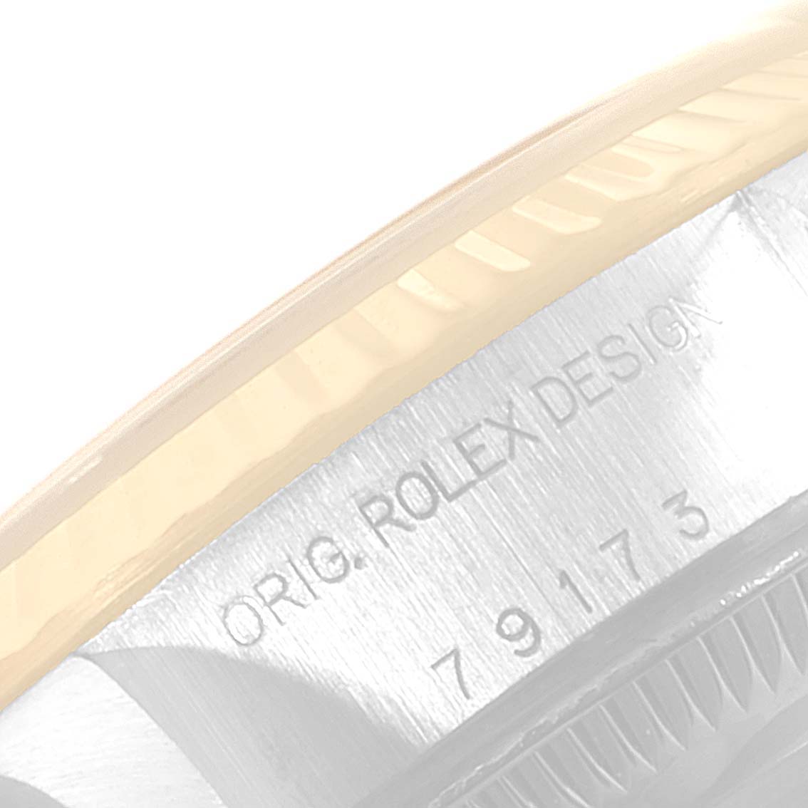 This image shows a partial side view of the bezel and engraved "ROLEX DESIGN" on a Rolex Datejust 79173 Women's Steel and Gold (two tone) White Dial 79173 Women's Steel and Gold (two tone) White Dial model.