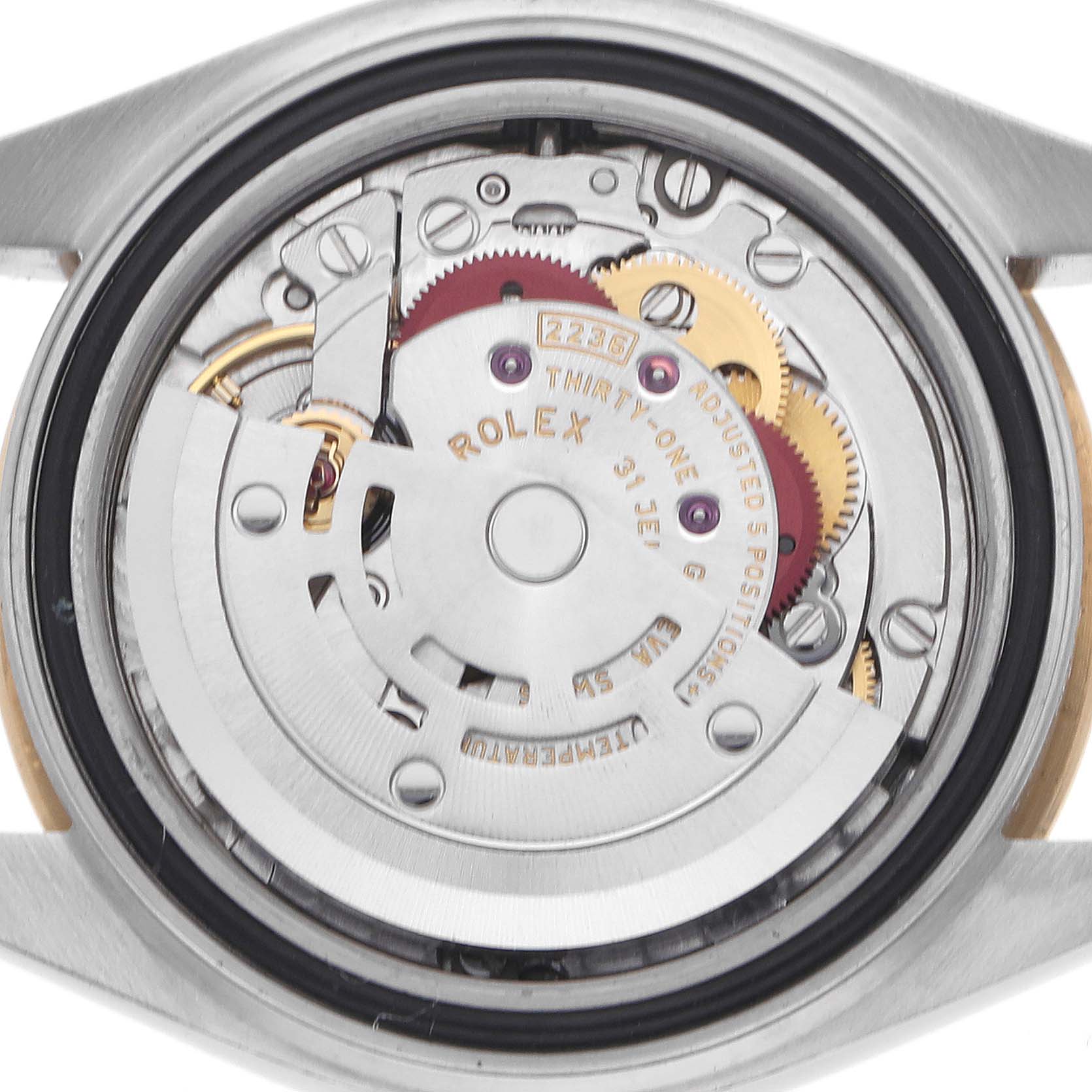 The image shows the movement of a Rolex Datejust watch from the back, highlighting gears and intricate components.