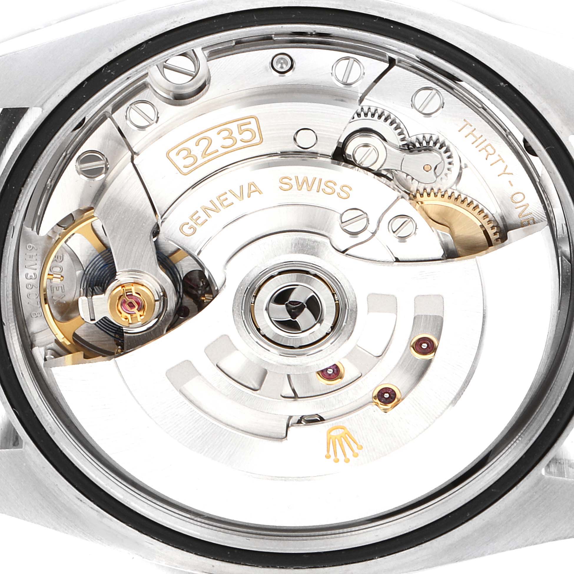 The image shows a close-up view of the movement mechanism of a Rolex Datejust 126200 Men
s Stainless Steel Black Dial 126200 Men
s Stainless Steel Black Dial watch, highlighting its intricate components and engravings.