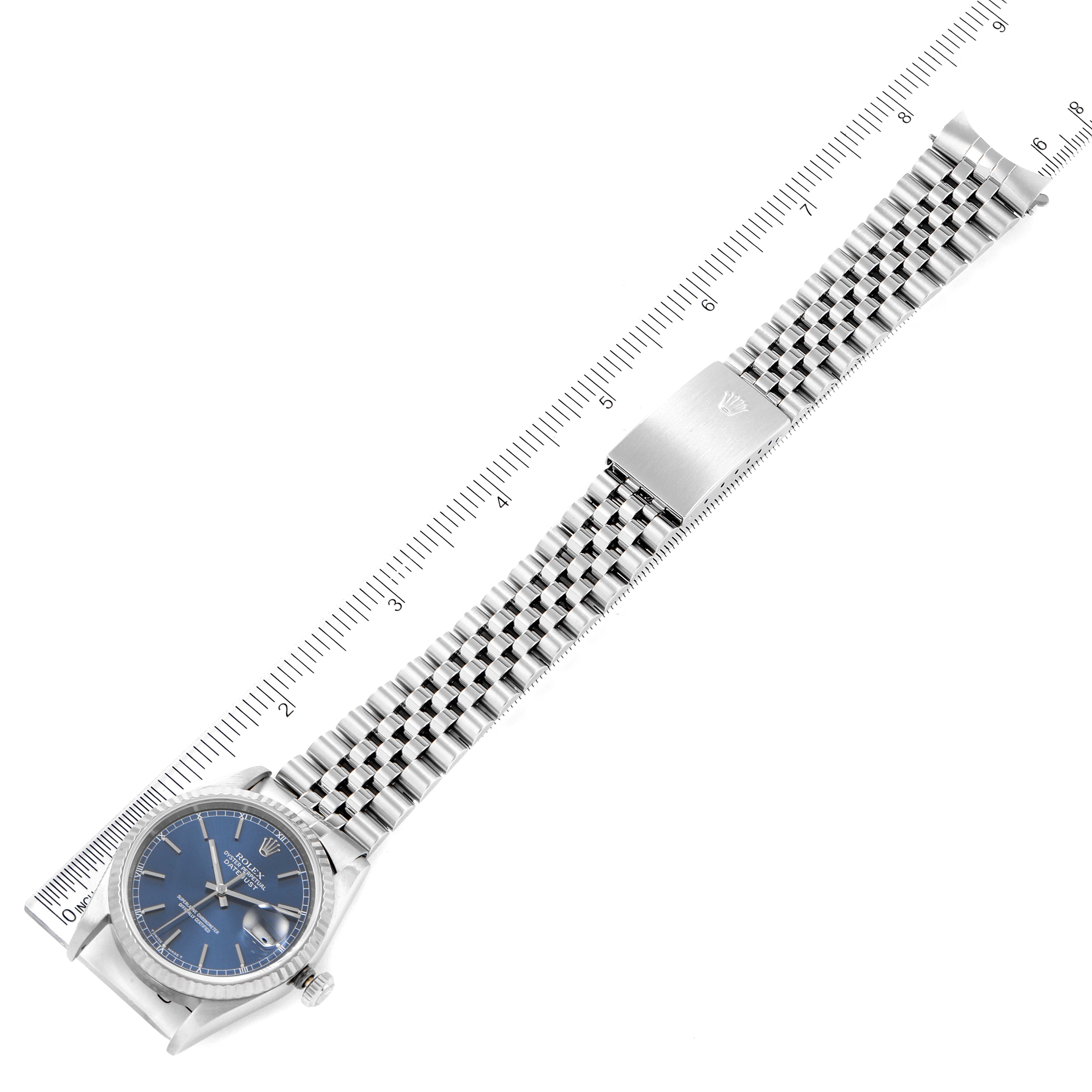 The image shows a Rolex Datejust 16234 Men's Stainless Steel Blue Dial 16234 Men's Stainless Steel Blue Dial watch laid flat, displaying the face, crown, and full bracelet with a ruler for scale.