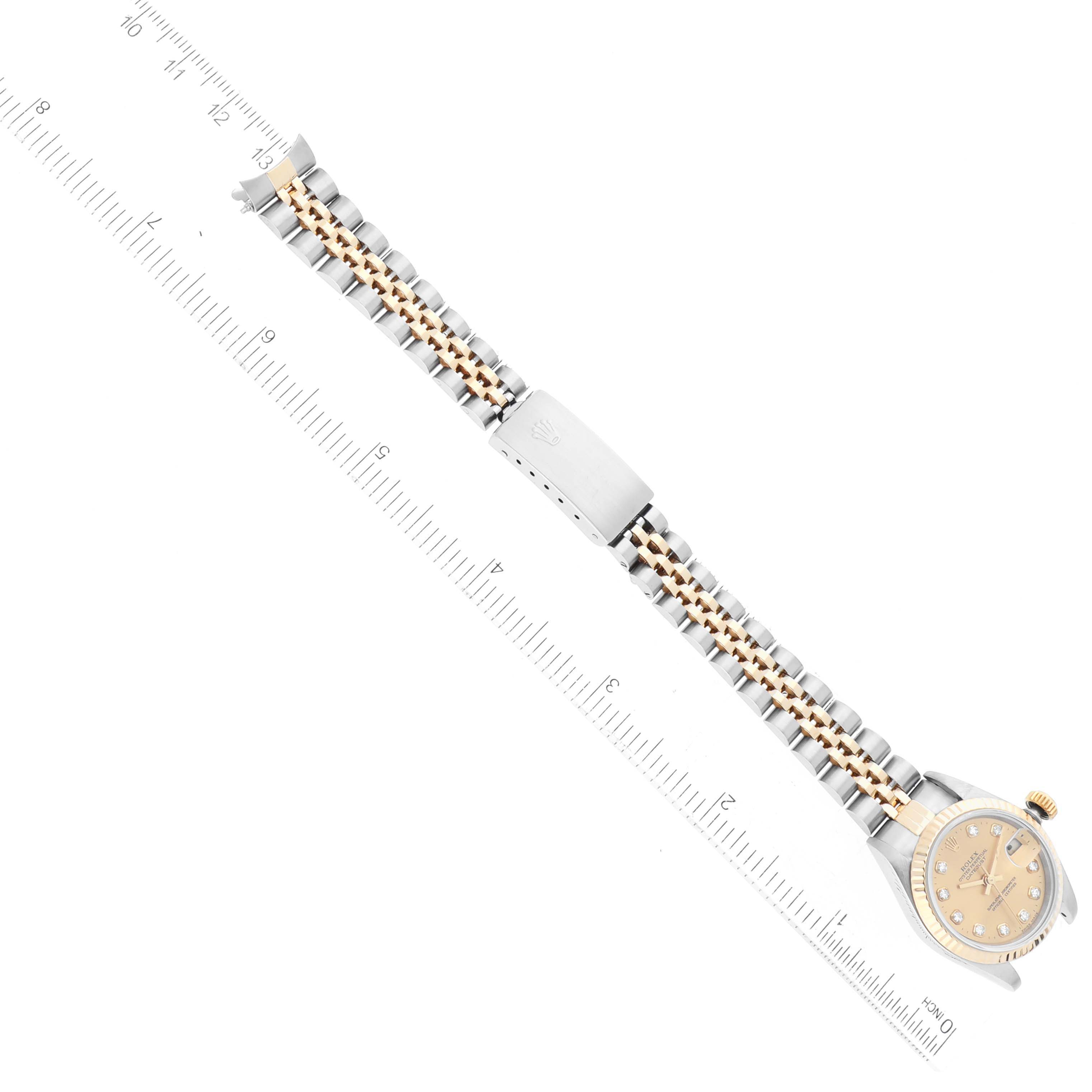 This image shows a Rolex Datejust 69173 Women's Steel and Gold (two tone) Champagne Dial 69173 Women's Steel and Gold (two tone) Champagne Dial watch laid flat with the face, bracelet, and clasp visible, alongside a measuring scale.