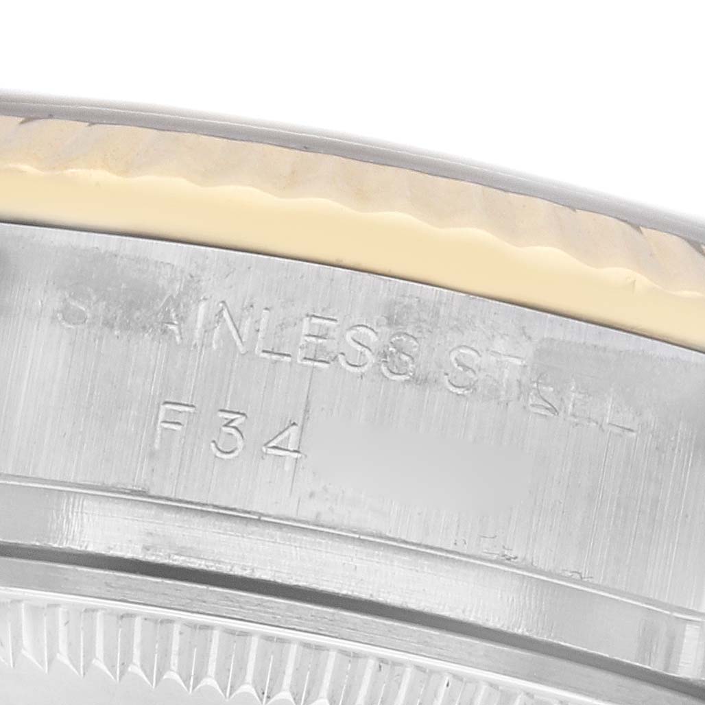 The image shows a close-up of the edge and markings on the case back of a Rolex Datejust 179173 Women
s Steel and Gold (two tone) Black Dial 179173 Women
s Steel and Gold (two tone) Black Dial watch.