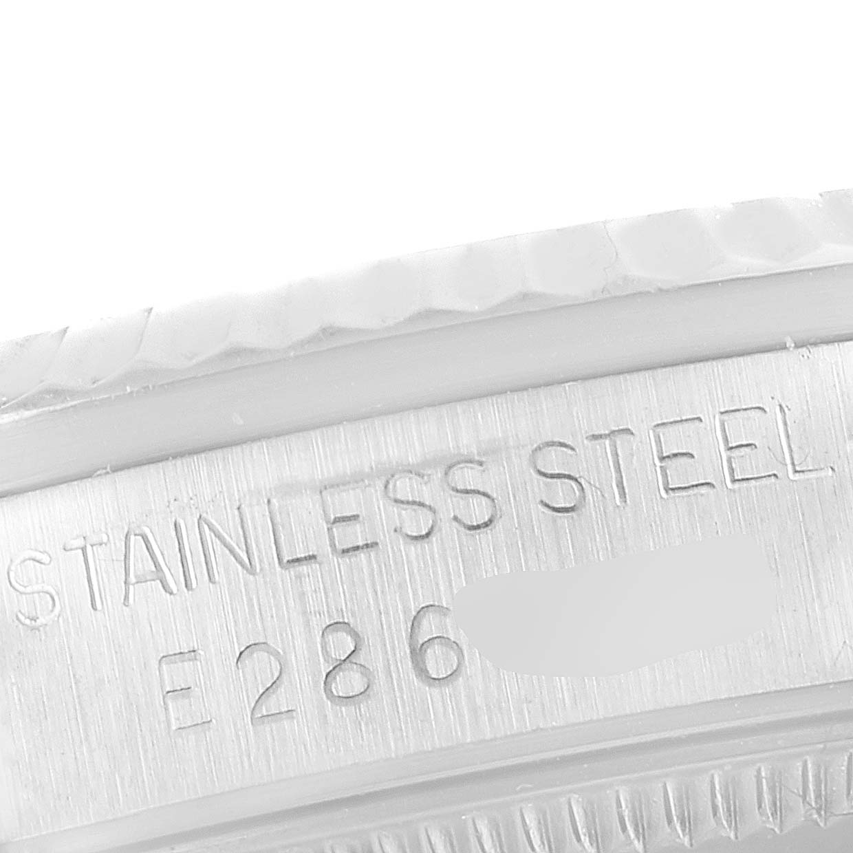 This close-up image of a Rolex Mid-Size 68274 Women
s Stainless Steel Silver Dial 68274 Women
s Stainless Steel Silver Dial watch shows the engraving on the stainless steel case with partial serial number.