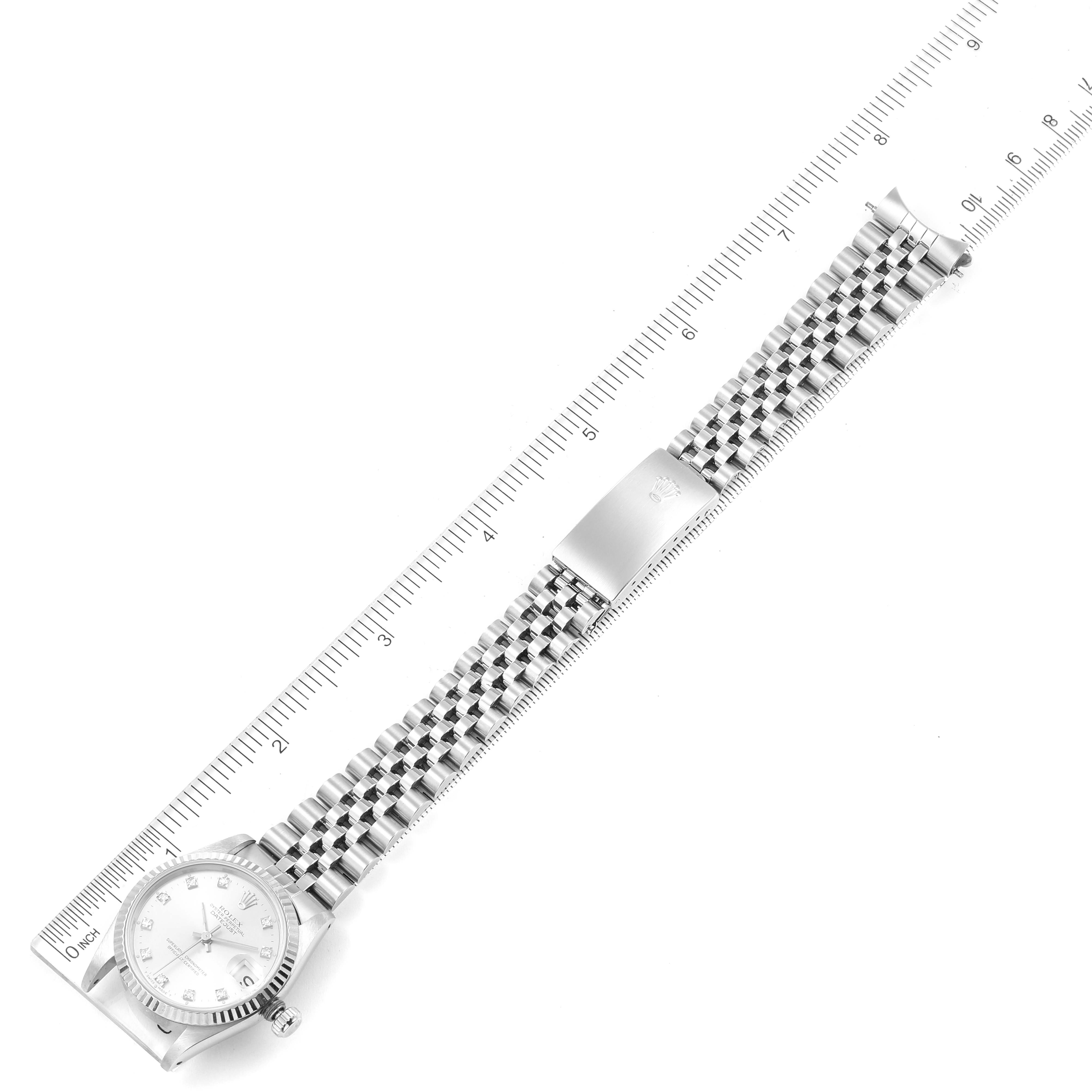 The image shows a full view of a Rolex Mid-Size 68274 Women
s Stainless Steel Silver Dial 68274 Women
s Stainless Steel Silver Dial model watch laid flat next to a ruler for measurement.