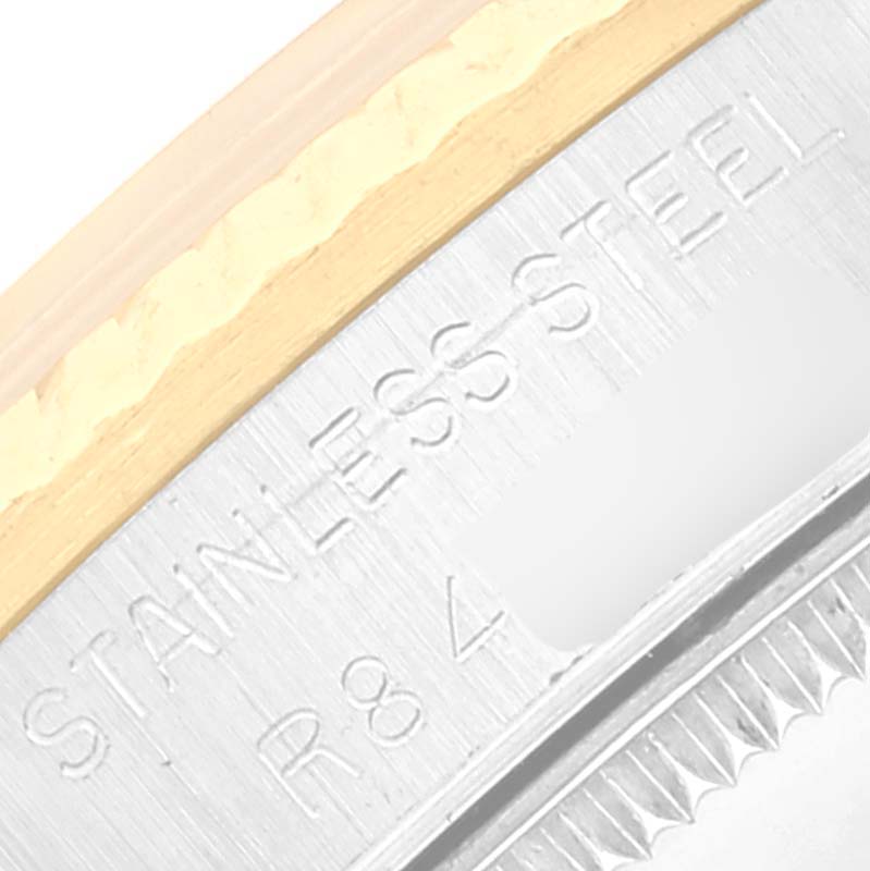 This image shows a close-up of the side engraving and bezel of a Mid-Size Rolex watch, highlighting the "STAINLESS STEEL" text.