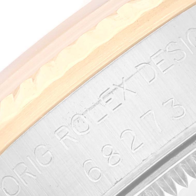 The image shows a close-up of the case side and part of the bezel of a Mid-Size Rolex watch, revealing engraved details.