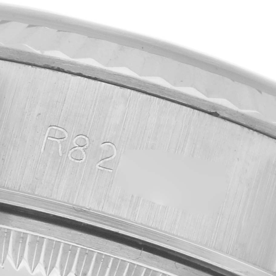 The image shows a close-up angle of a Rolex Datejust 69174 Women
s Stainless Steel Silver Dial 69174 Women
s Stainless Steel Silver Dial model
s engraved watch case edge.