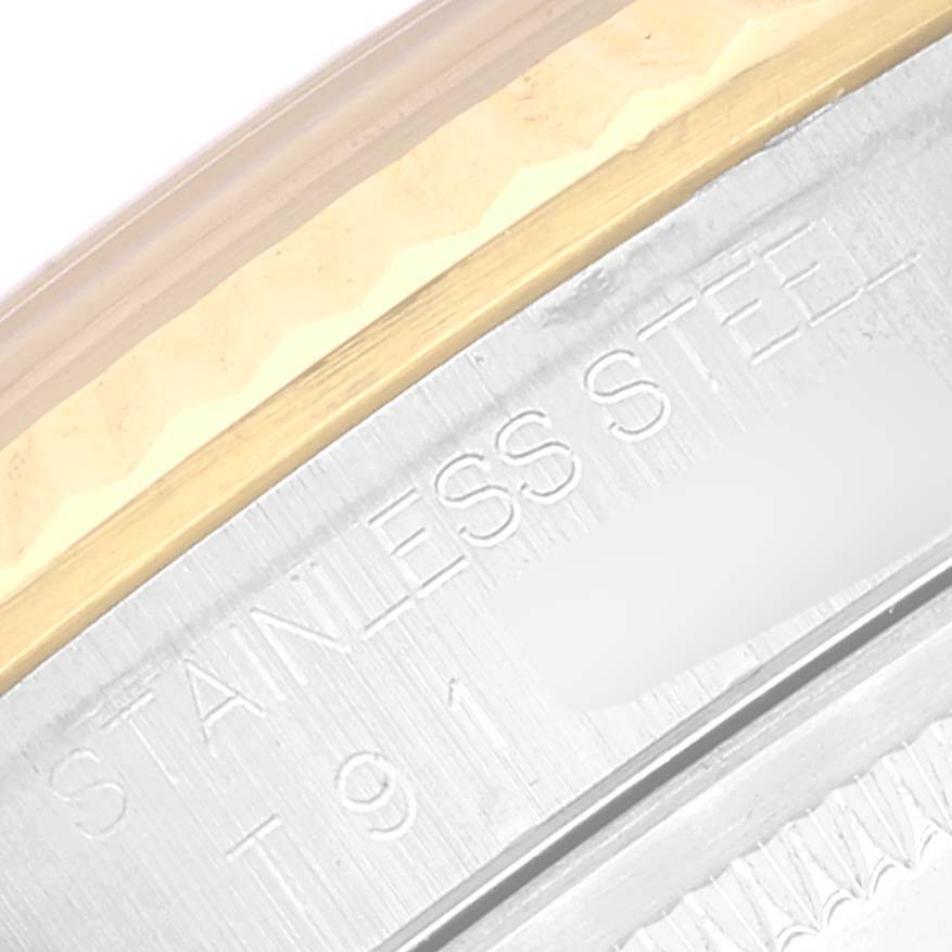 This is an extreme close-up of the case and bezel of a Rolex Datejust 16233 Men's Steel and Gold (two tone) Blue Dial 16233 Men's Steel and Gold (two tone) Blue Dial, focusing on the engraving "STAINLESS STEEL."