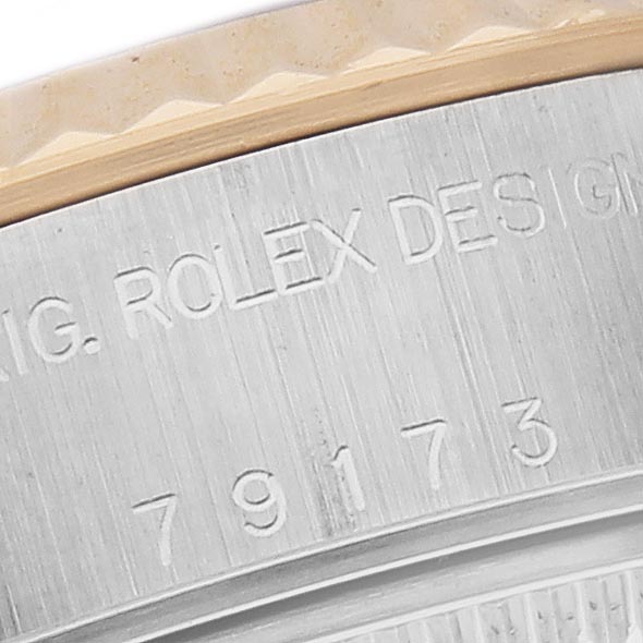The image shows a close-up view of the side engraving on a Rolex Datejust 79173 Women
s Steel and Gold (two tone) Champagne Dial 79173 Women
s Steel and Gold (two tone) Champagne Dial case, highlighting the model number and “Rolex Design” text.