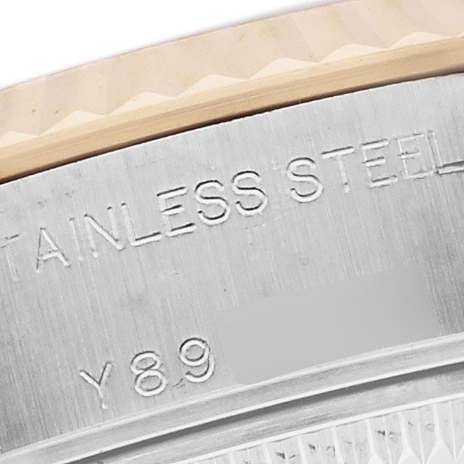 The image shows a close-up of the Rolex Datejust 79173 Women
s Steel and Gold (two tone) Champagne Dial 79173 Women
s Steel and Gold (two tone) Champagne Dial
s fluted bezel and part of the stainless steel case back.