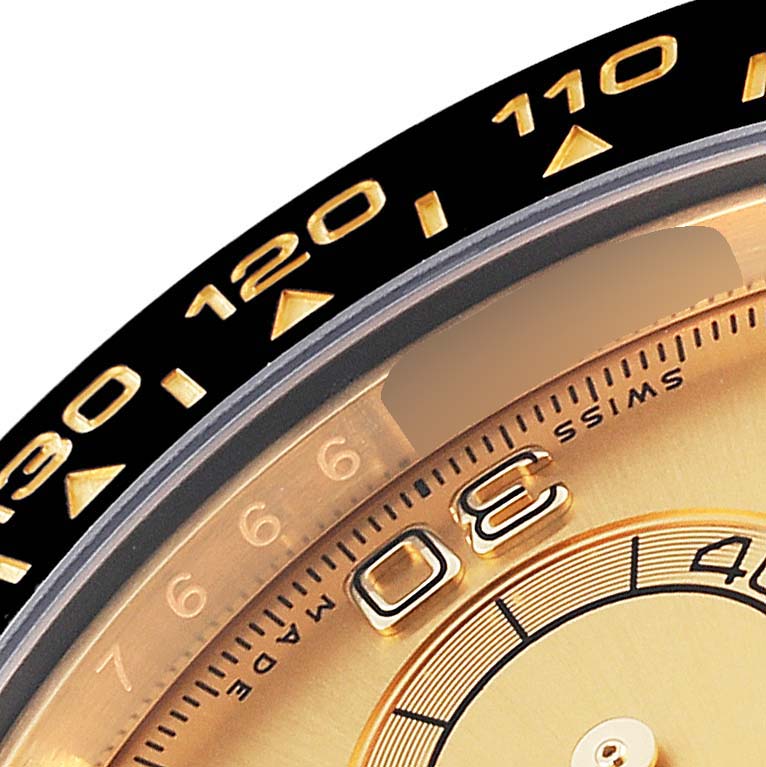 This image shows a close-up of the bezel and part of the dial of a Rolex Daytona 116518 Men's Yellow Gold Champagne Dial 116518 Men's Yellow Gold Champagne Dial watch.