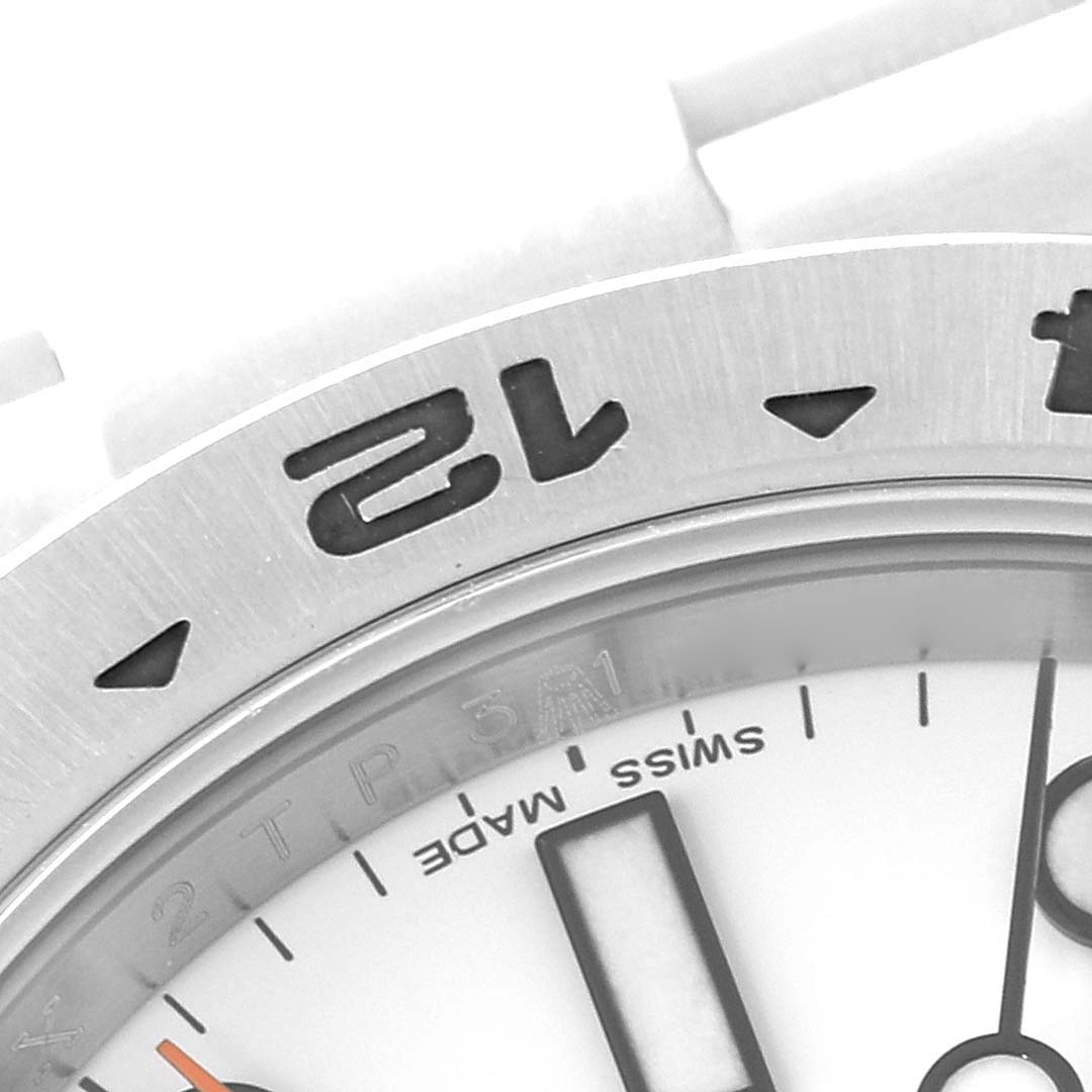 The image shows a close-up of the bezel and part of the dial of a Rolex Explorer 216570 Men
s Stainless Steel White Dial 216570 Men
s Stainless Steel White Dial watch.