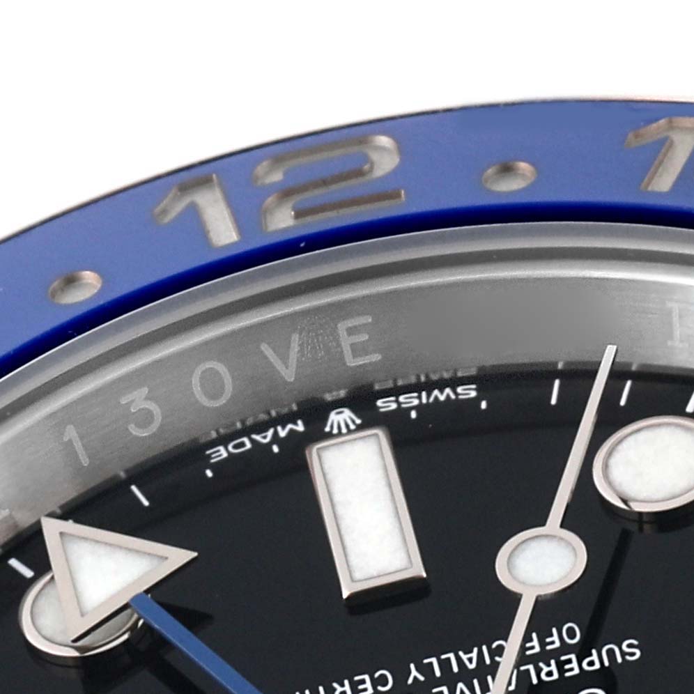 This image of a Rolex GMT-Master 126710 Men's Stainless Steel Black Dial 126710 Men's Stainless Steel Black Dial watch shows a close-up of the bezel, part of the dial, and the hour hand with the 12 marker in focus.