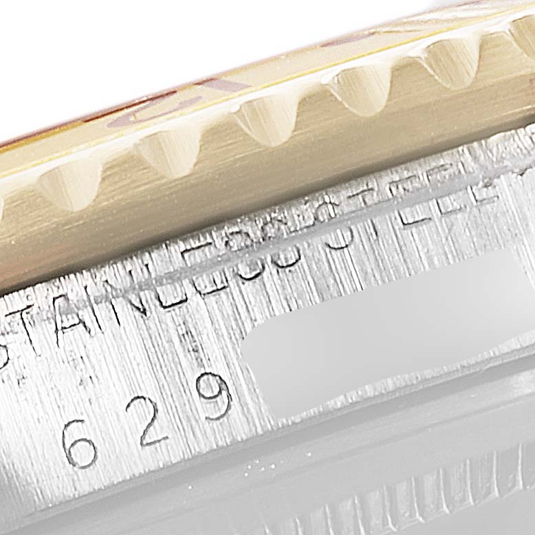 This close-up angle shows the bezel edge and part of the engraved serial number of a Vintage Collection Rolex watch.