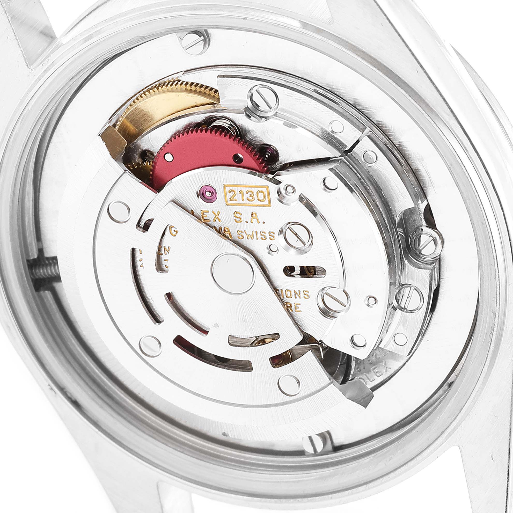 The image shows the internal mechanism of a Mid-Size Rolex model, viewed from the back with parts of the movement visible.