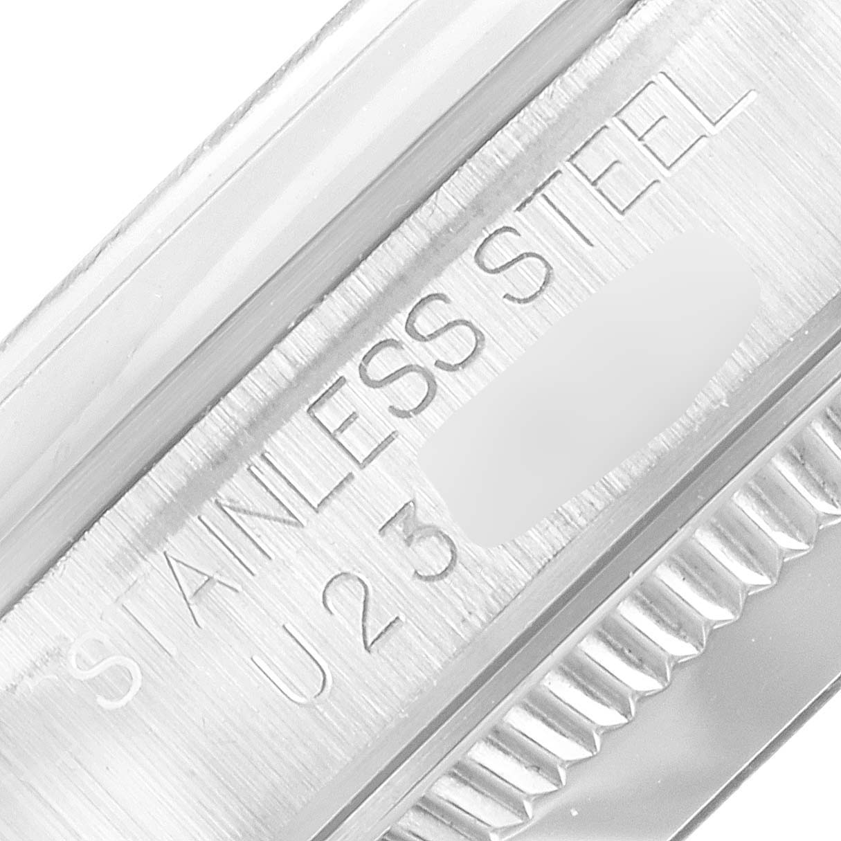 This close-up image shows the side of the bezel and case of the Mid-Size Rolex watch with "STAINLESS STEEL" engraved on it.