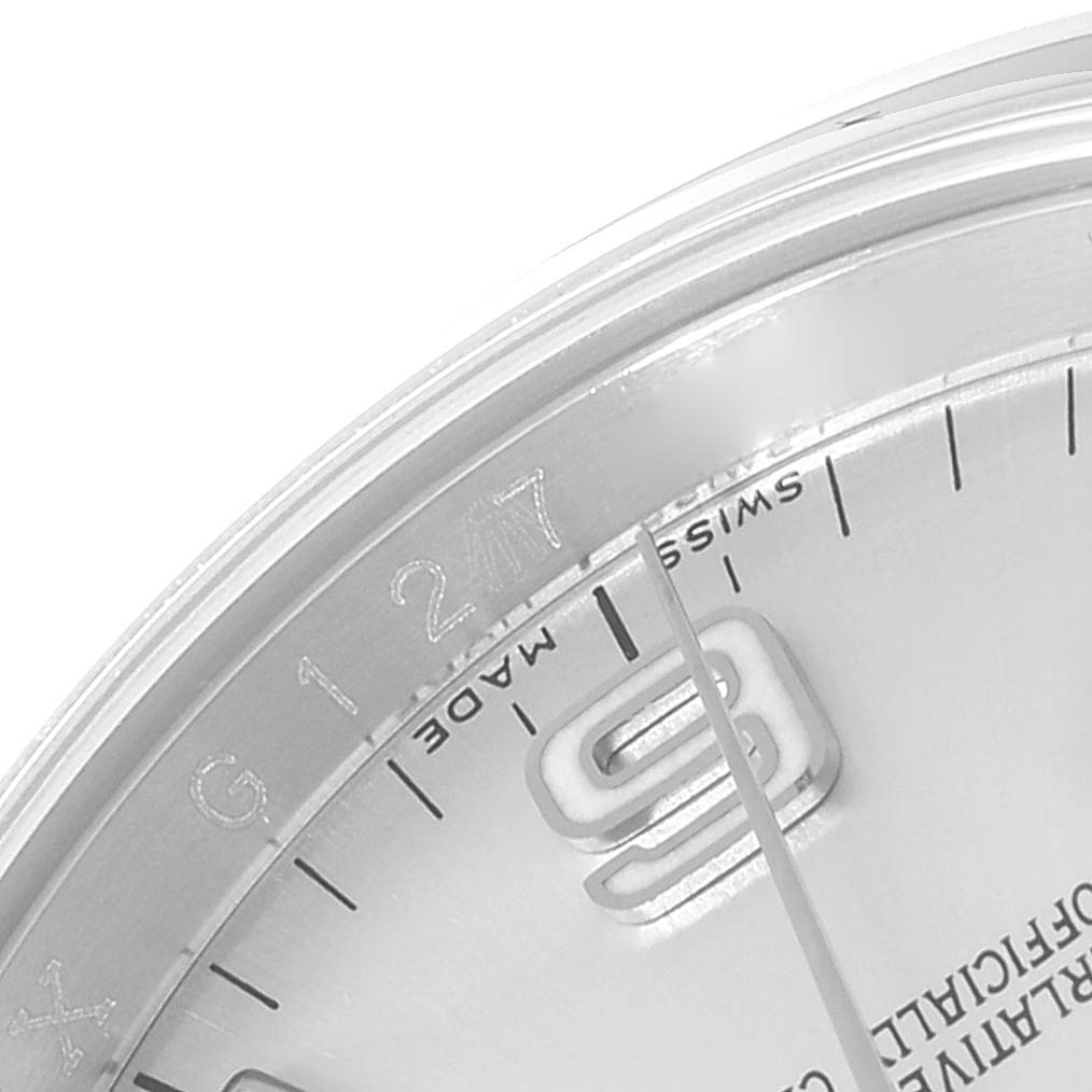The image shows a close-up of the dial, bezel, and partial numbers of a Rolex Oyster Perpetual 116000 Men's Stainless Steel Silver Dial 116000 Men's Stainless Steel Silver Dial model watch.