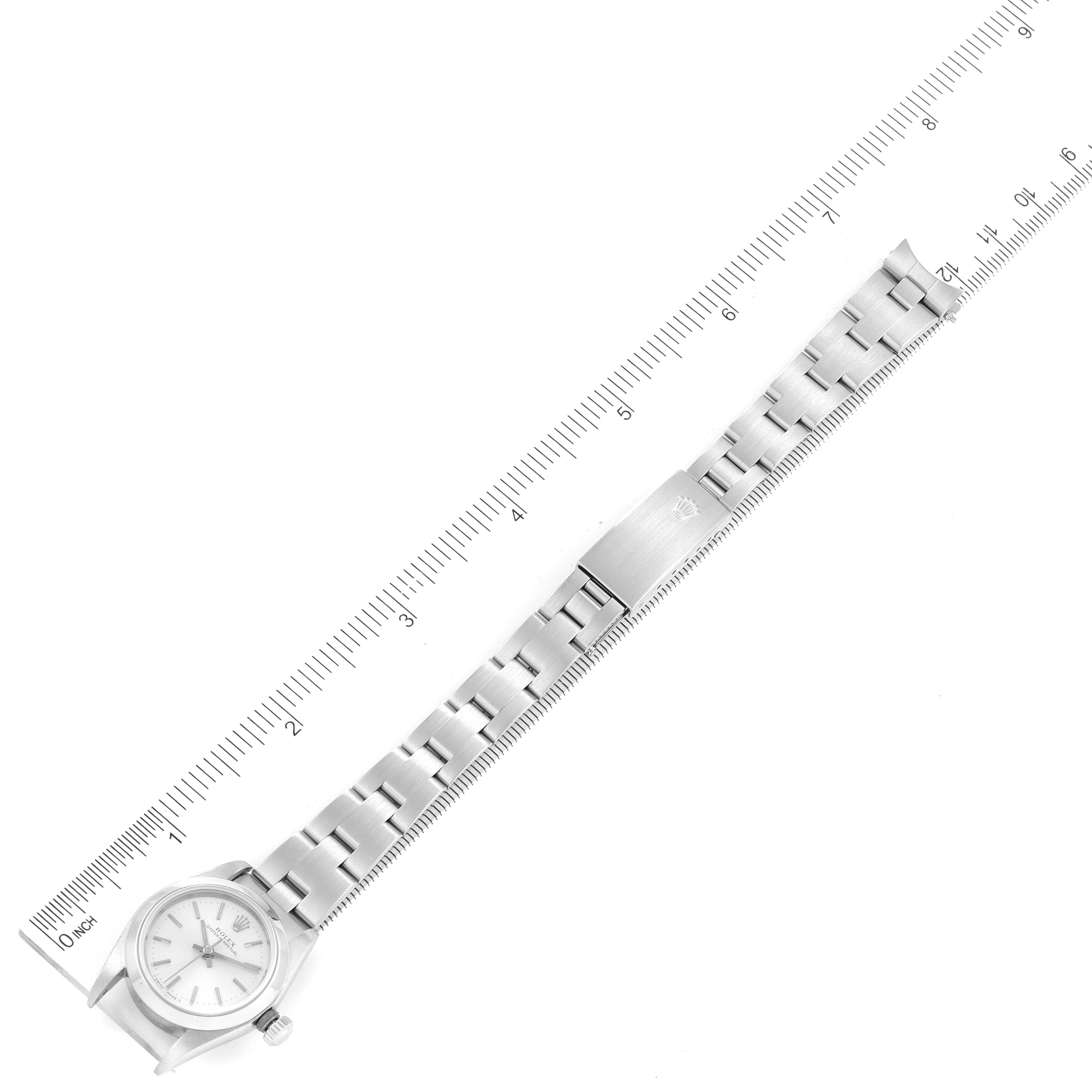 The Rolex Oyster Perpetual 76080 Women
s Stainless Steel Silver Dial 76080 Women
s Stainless Steel Silver Dial watch is shown from a top-down angle, displaying the face, bracelet, and clasp, along with a measuring scale.