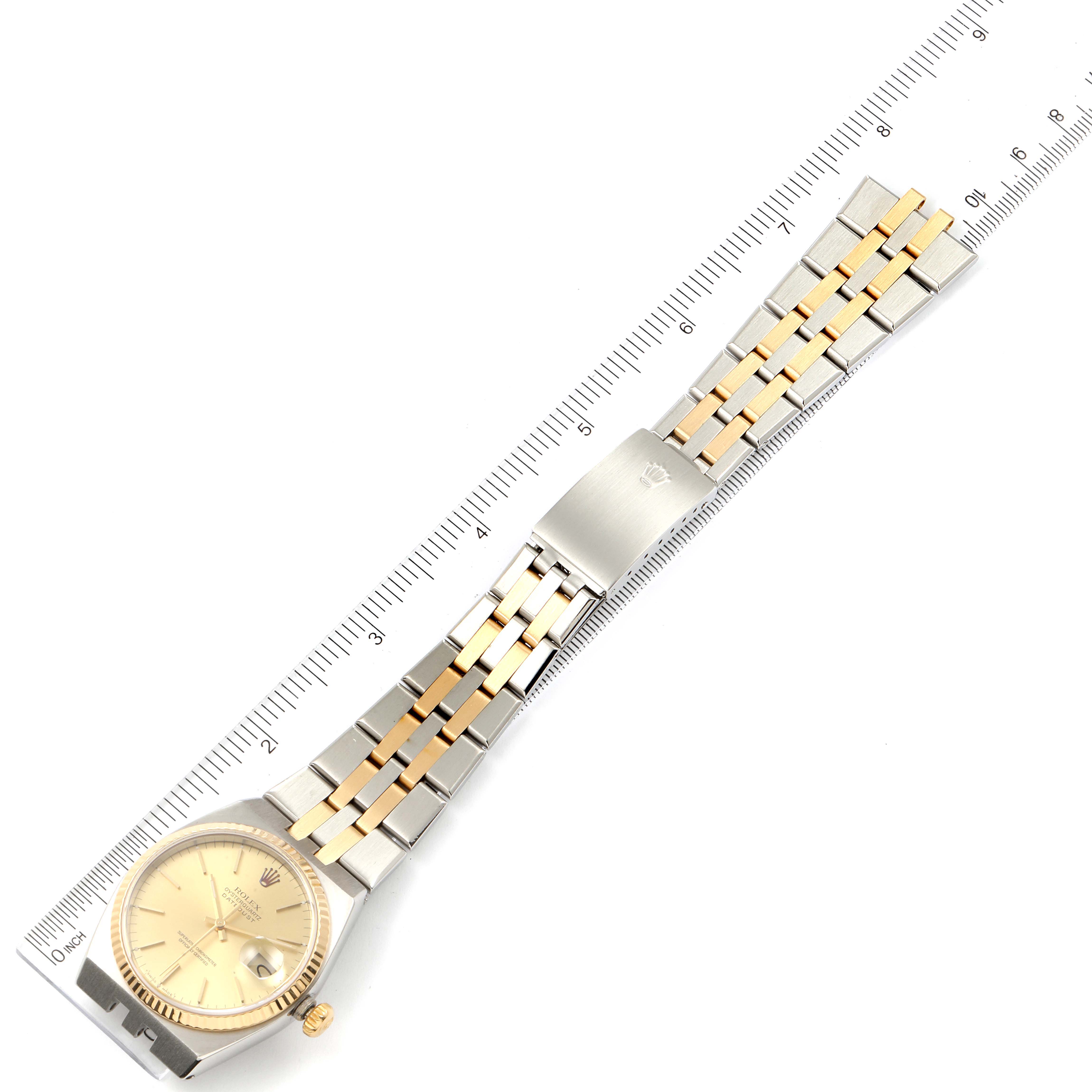 The image shows a top-down view of a Rolex Oysterquartz 17013 Men's Steel and Gold (two tone) Champagne Dial 17013 Men's Steel and Gold (two tone) Champagne Dial watch, including the dial, bracelet, and clasp, next to a ruler.