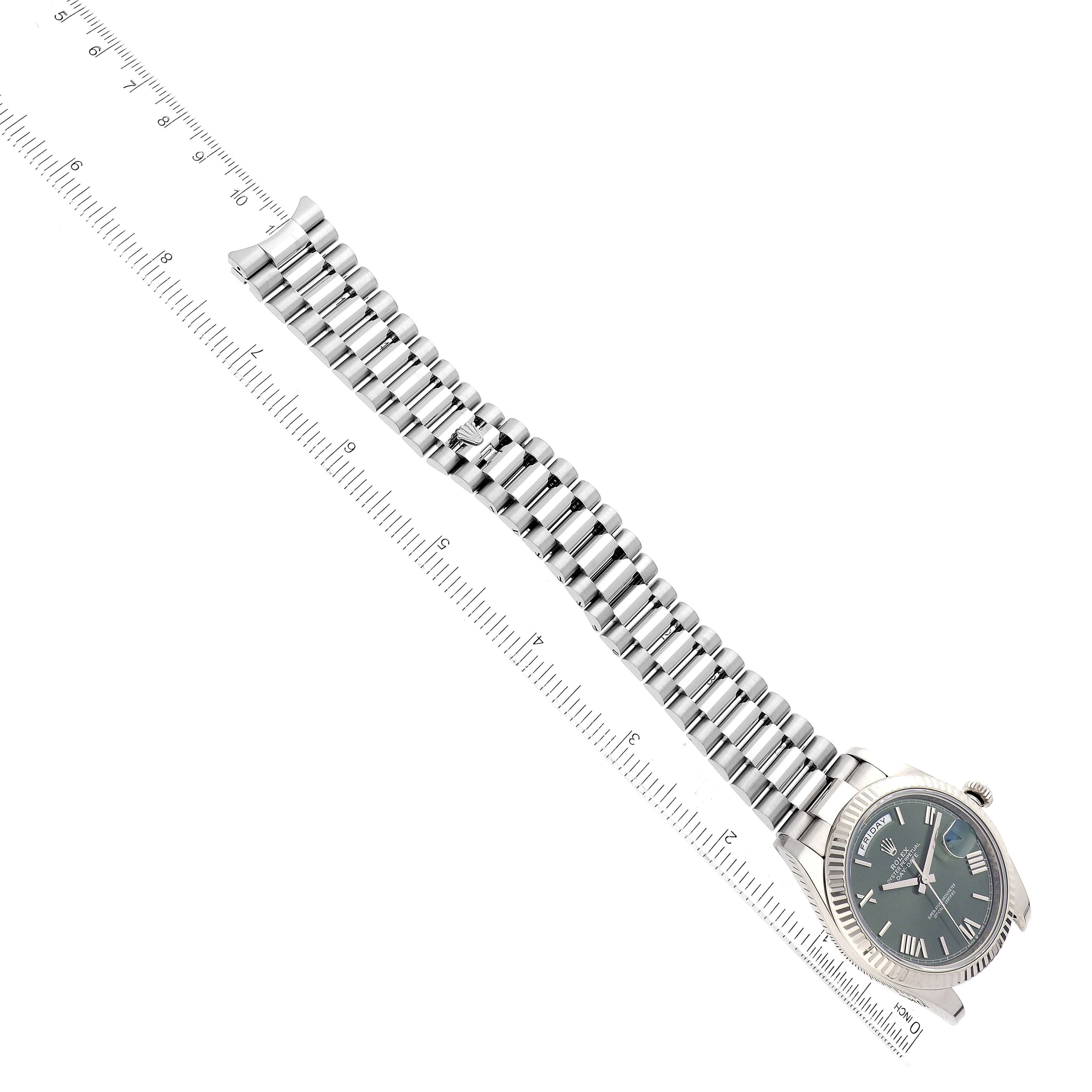 The image shows a top view of a Rolex President 61522 Men's White Gold Green Dial 61522 Men's White Gold Green Dial model watch with a focus on its bracelet next to a ruler for scale.