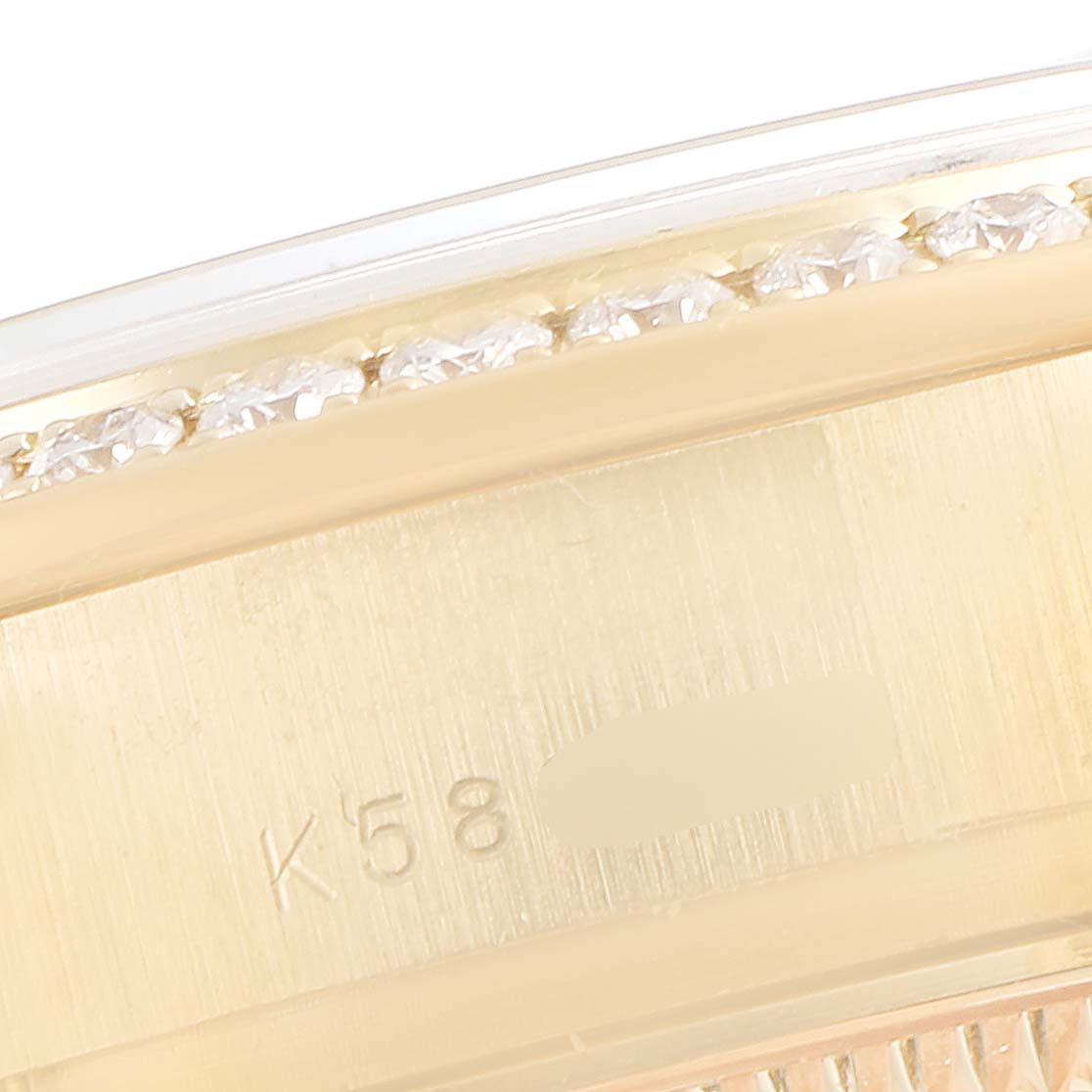 This close-up image shows the side detail of a Rolex President 179138 Women
s Yellow Gold Mother of Pearl Dial 179138 Women
s Yellow Gold Mother of Pearl Dial model, highlighting the bezel and part of the case with engravings.