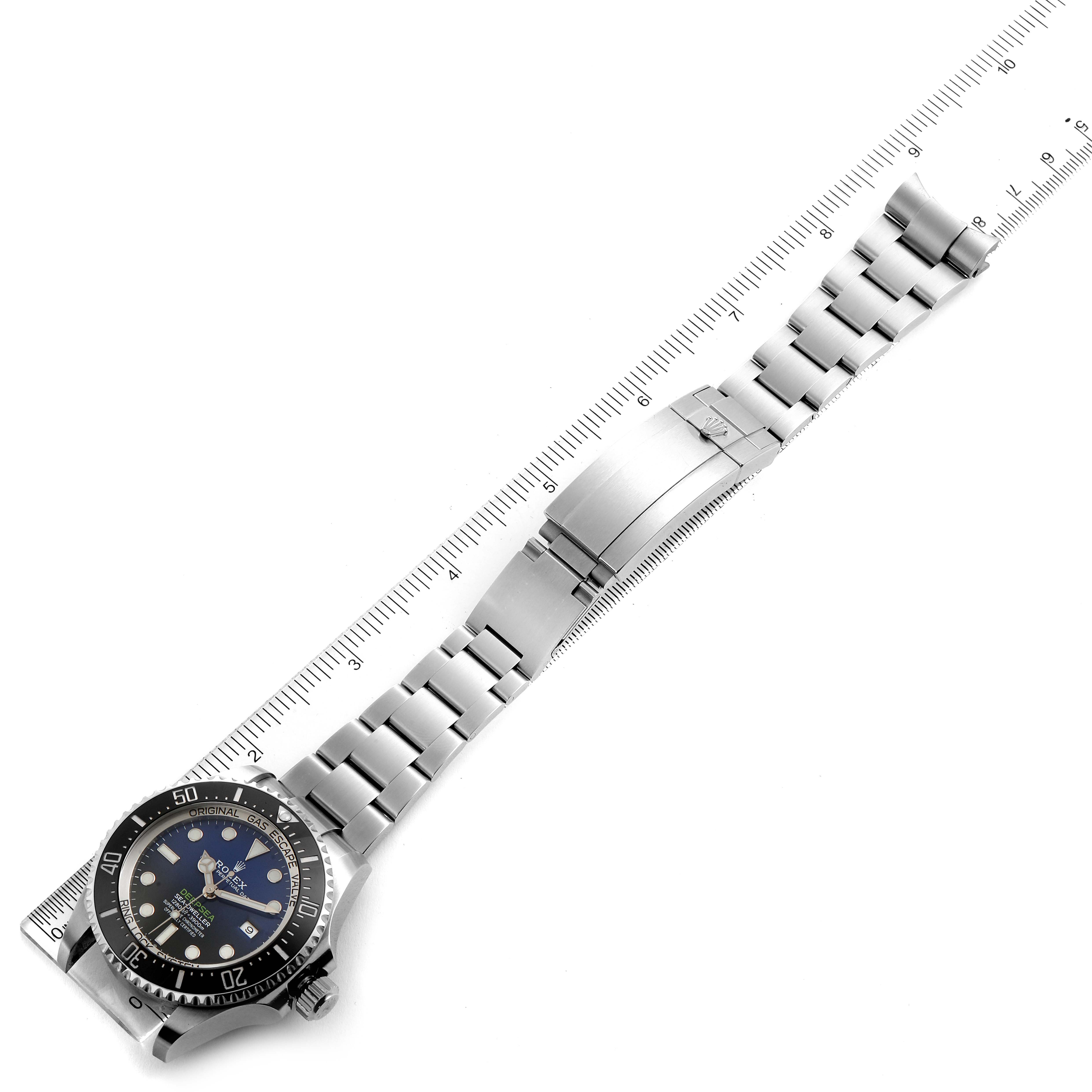 The Rolex Sea-Dweller 126660 Men
s Stainless Steel Blue Dial 126660 Men
s Stainless Steel Blue Dial watch is shown from a top-down angle, displaying the face, bracelet, and clasp, alongside a ruler for scale.