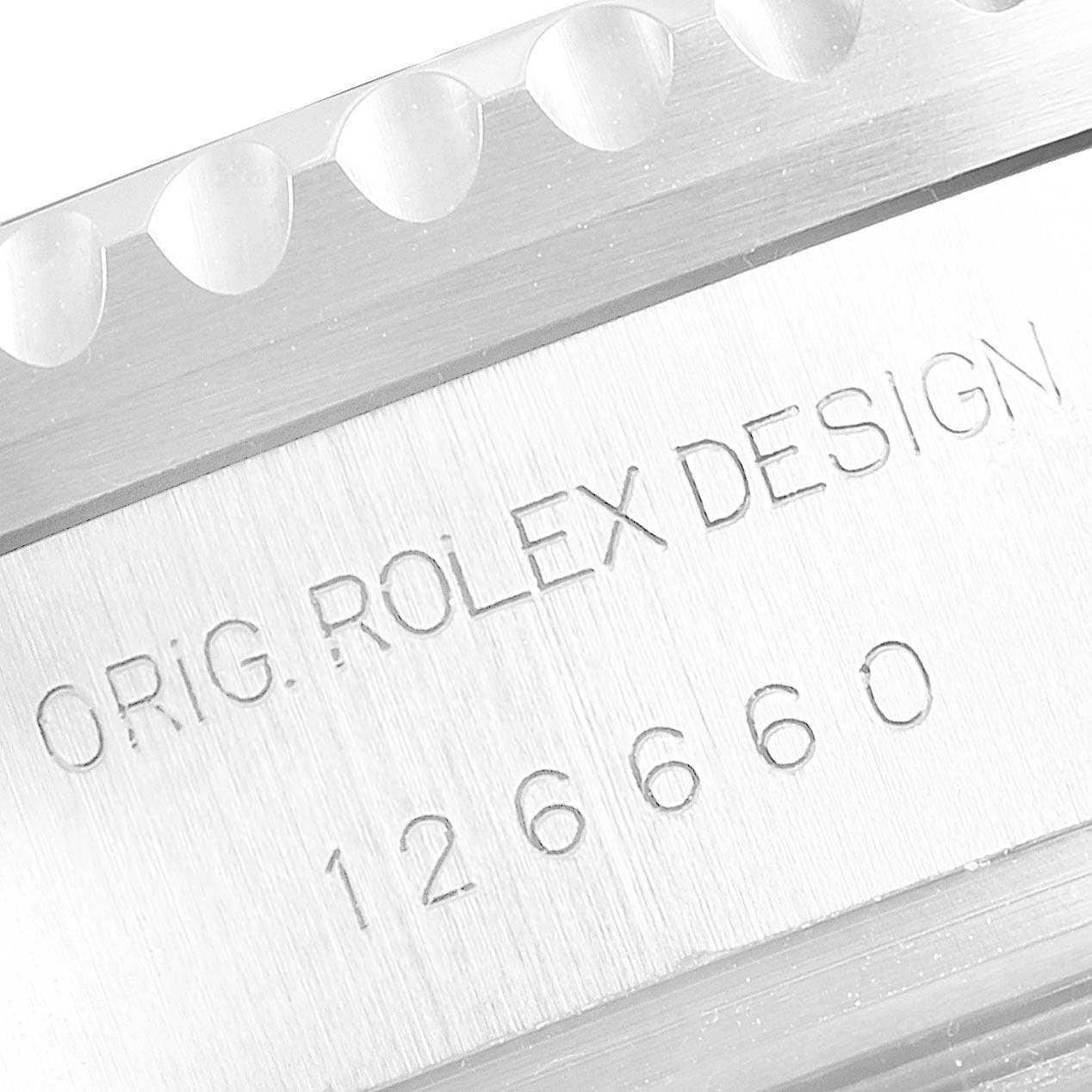 The image shows a close-up angle of the side of a Rolex Sea-Dweller 126660 Men
s Stainless Steel Blue Dial 126660 Men
s Stainless Steel Blue Dial, featuring engraved text and part of the bezel.