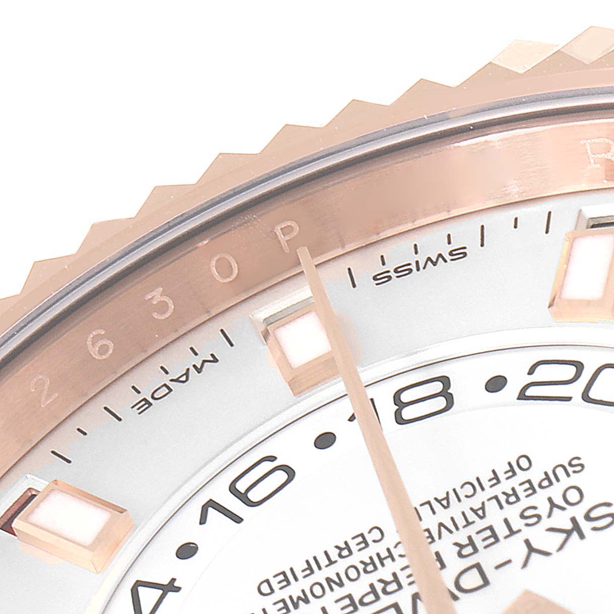 This close-up image shows the bezel, part of the dial, and the hour markers of a Rolex Sky-Dweller 326935 Men's Rose Gold White Dial 326935 Men's Rose Gold White Dial watch.