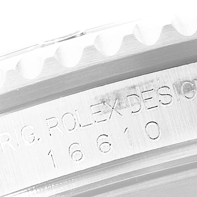 The image shows a close-up of the engraved side of the bezel and casing of a Rolex Submariner 16610 Men's Stainless Steel Black Dial 16610 Men's Stainless Steel Black Dial model 16610.