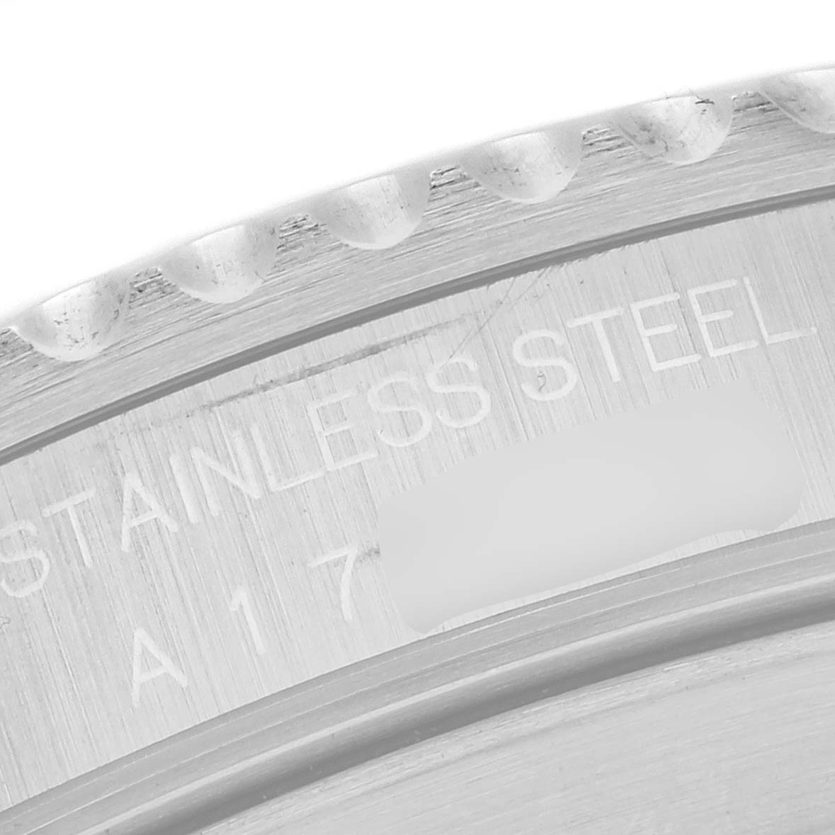 The image shows the engraved inner rim of the bezel and part of the case back of a Rolex Submariner 14060 Men
s Stainless Steel Black Dial 14060 Men
s Stainless Steel Black Dial watch, highlighting its stainless steel material.