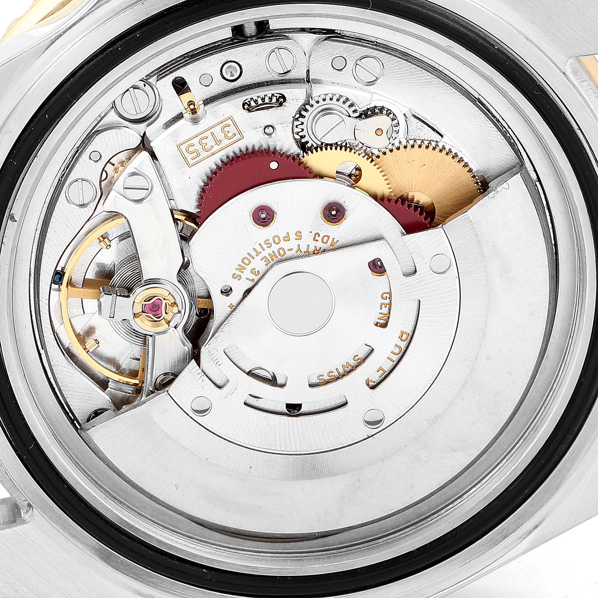 The image shows the intricate internal mechanism of a Rolex Submariner 16613 Men
s Steel and Gold (two tone) Grey Dial 16613 Men
s Steel and Gold (two tone) Grey Dial watch from a rear angle, highlighting its gears and movement components.