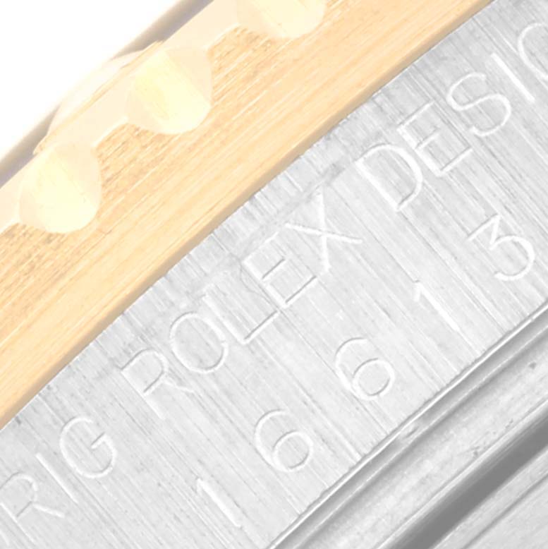 This close-up image shows part of the bezel and engraved case back of a Rolex Submariner 16613 Men's Steel and Gold (two tone) Black Dial 16613 Men's Steel and Gold (two tone) Black Dial watch.