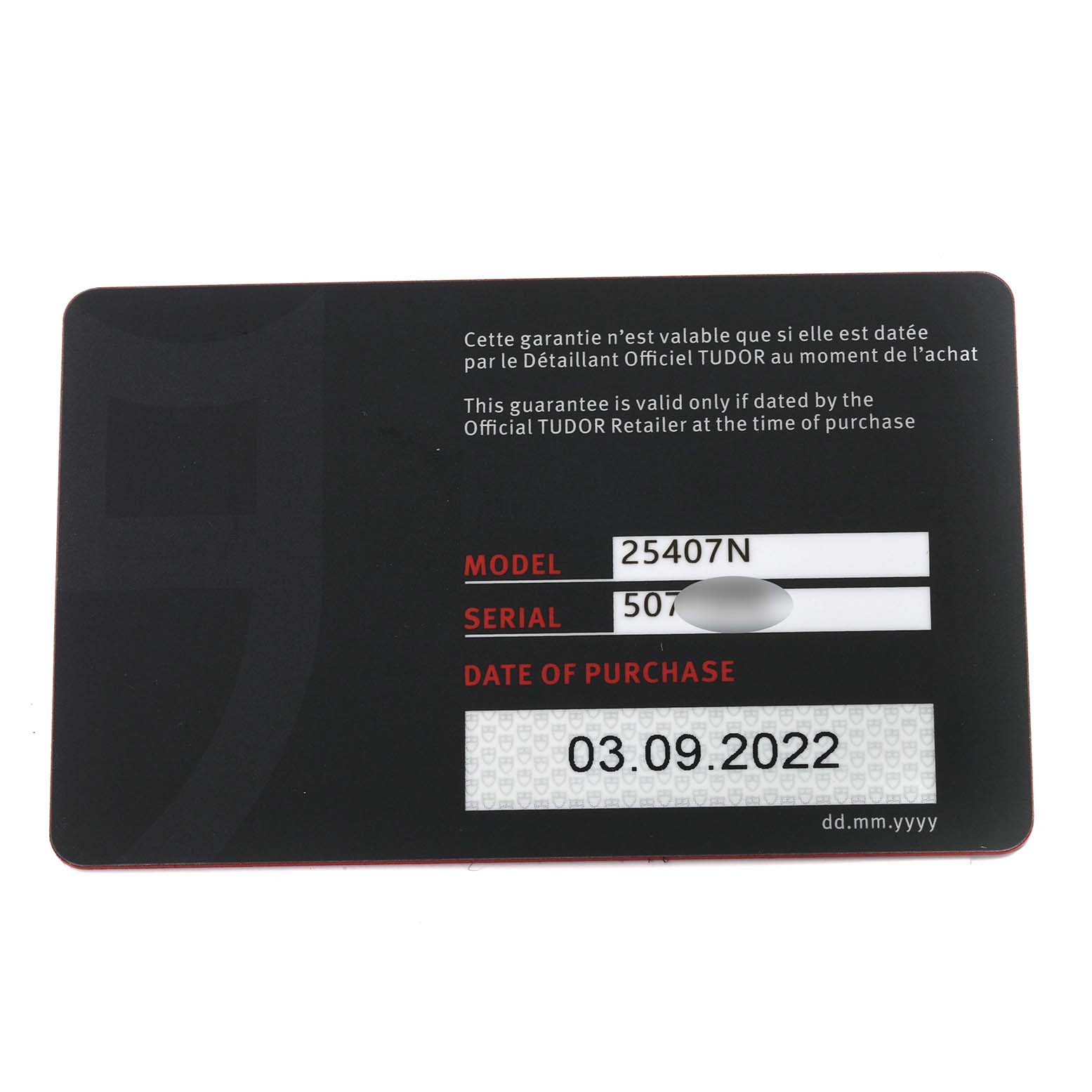 The image shows the warranty card for a Tudor Pelagos 25407N Men
s Titanium Black Dial 25407N Men
s Titanium Black Dial model watch from a top-down angle.