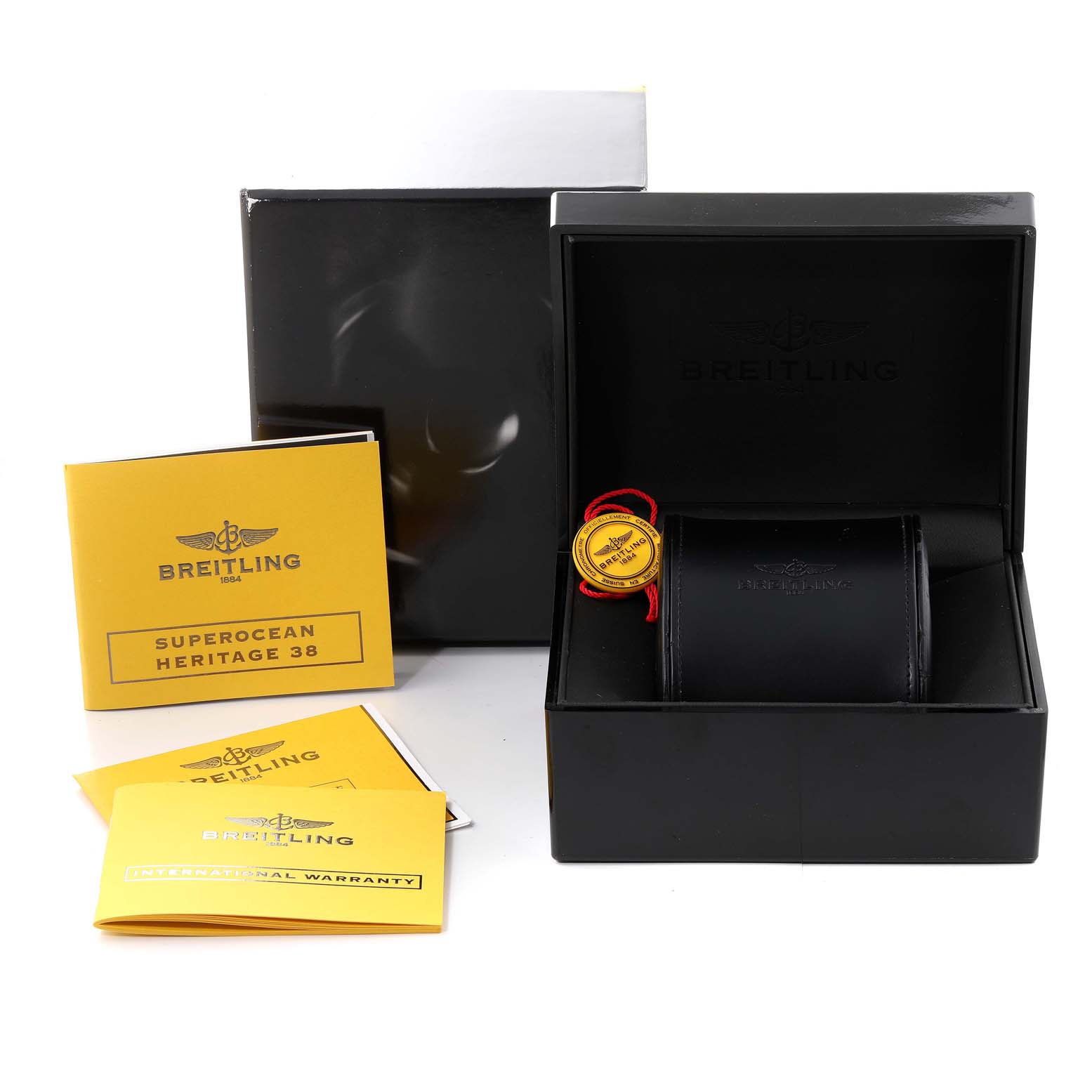 The image shows the Breitling Superocean A3732016/C735 Men's Stainless Steel Blue Dial A3732016/C735 Men's Stainless Steel Blue Dial Heritage 38 box, warranty cards, and an empty watch holder at a slightly elevated angle.