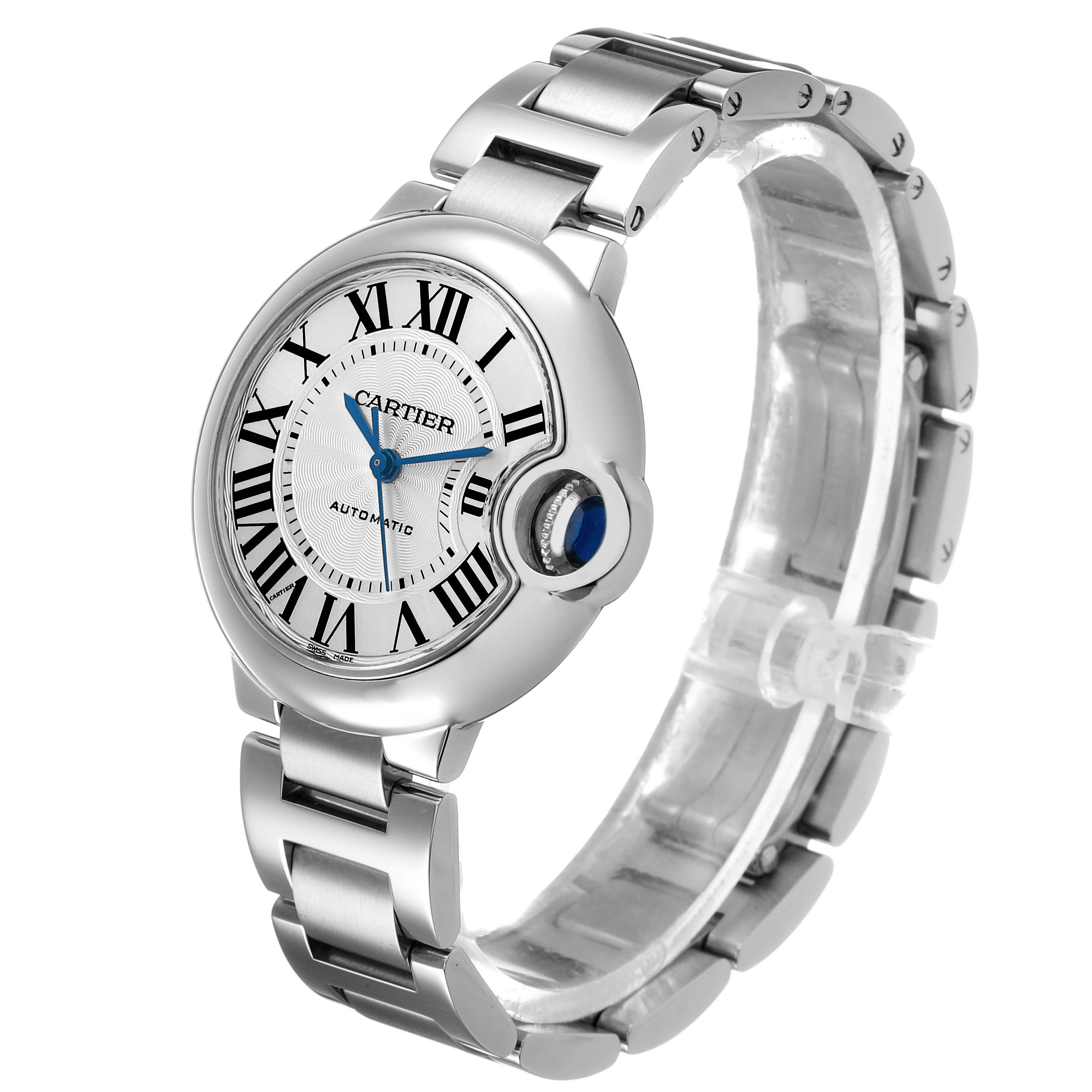 The Cartier Ballon Bleu W6920071 Women's Stainless Steel Silver Dial watch is shown at a three-quarter angle, highlighting its round case, blue sapphire crown, and metal bracelet.