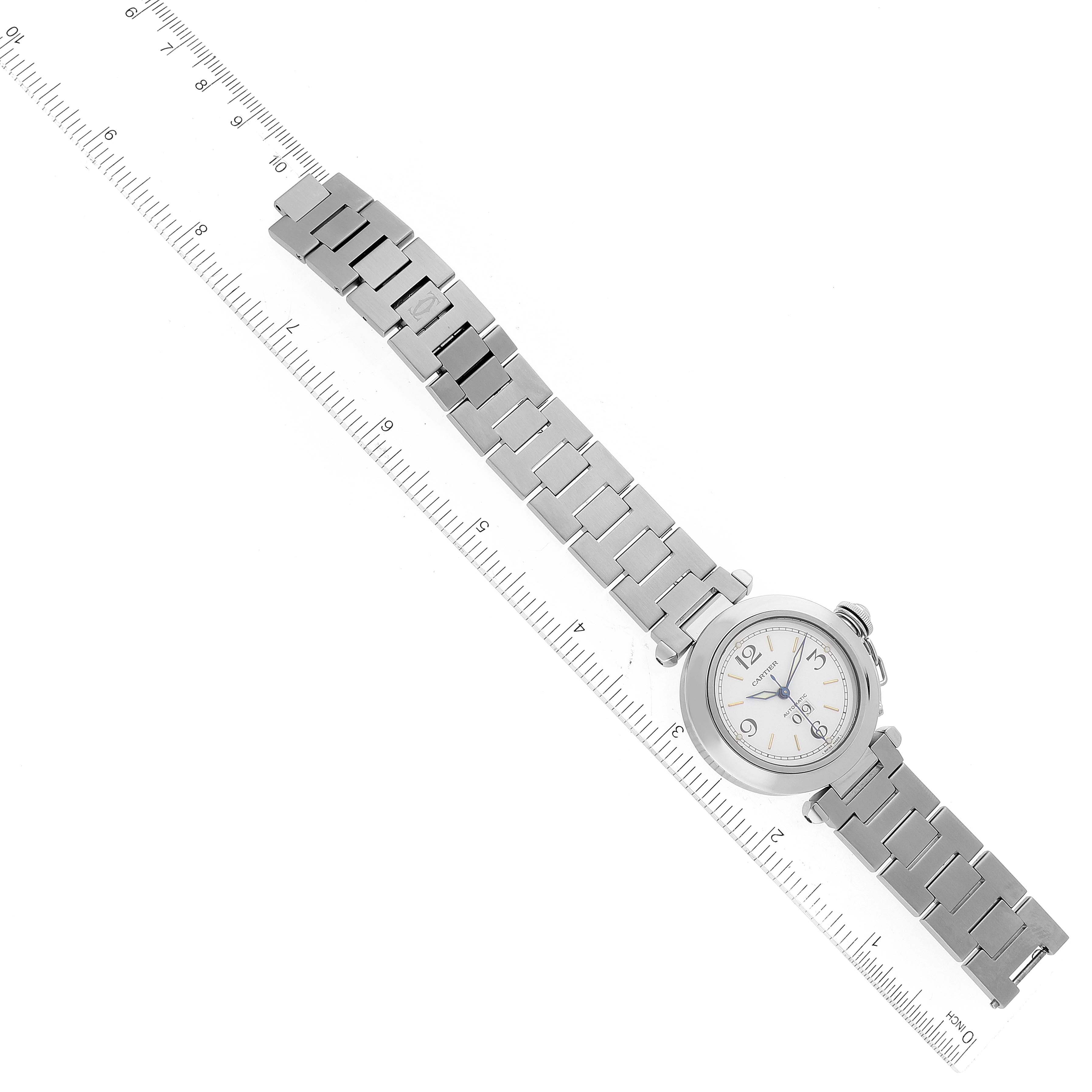 The watch is a Pasha model by Cartier, shown from an overhead angle with its full metal bracelet and a ruler for scale.