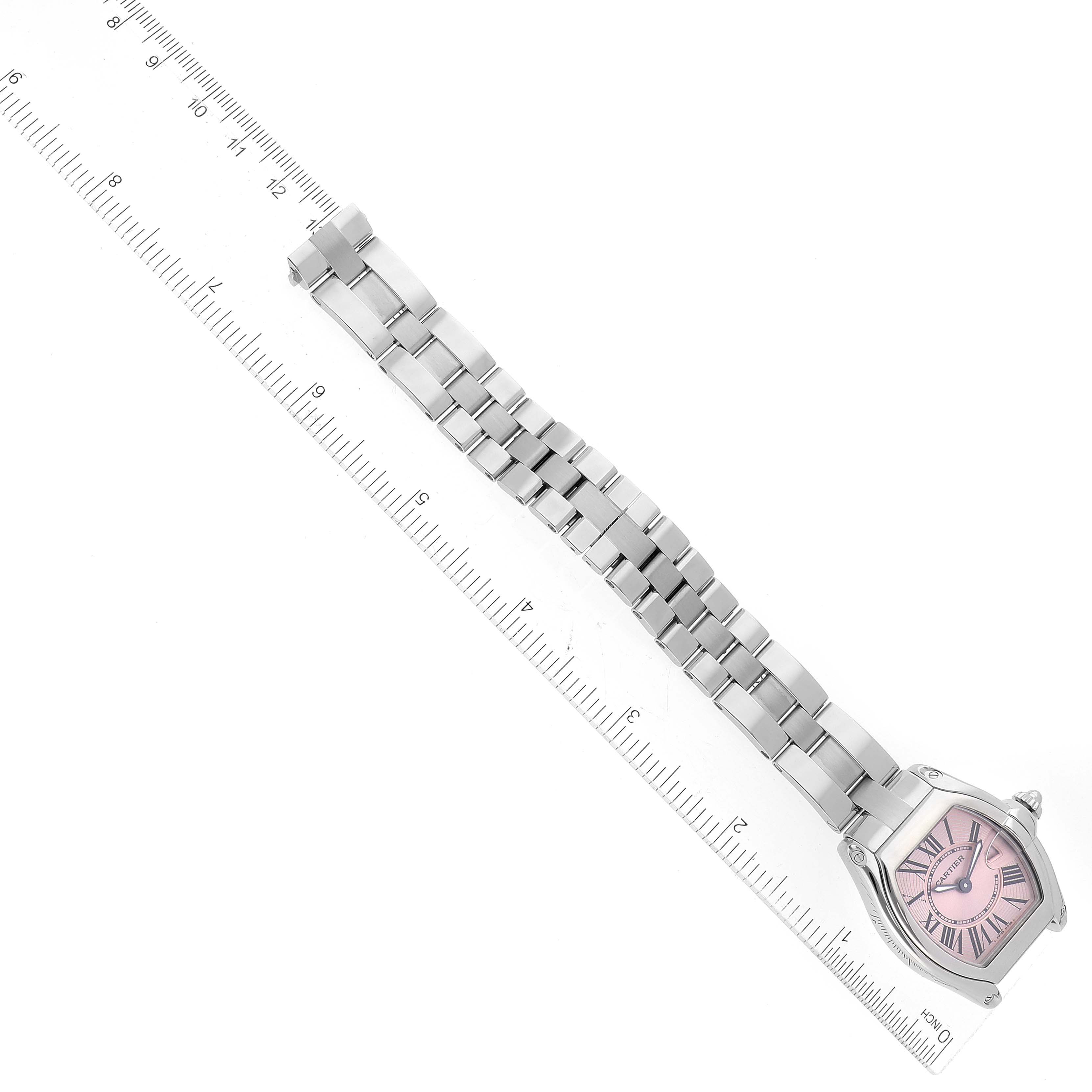 The Cartier Roadster W62017V3 Women's Stainless Steel Pink Dial W62017V3 Women's Stainless Steel Pink Dial watch is shown from above, displaying the full band and the pink dial next to a ruler for scale.