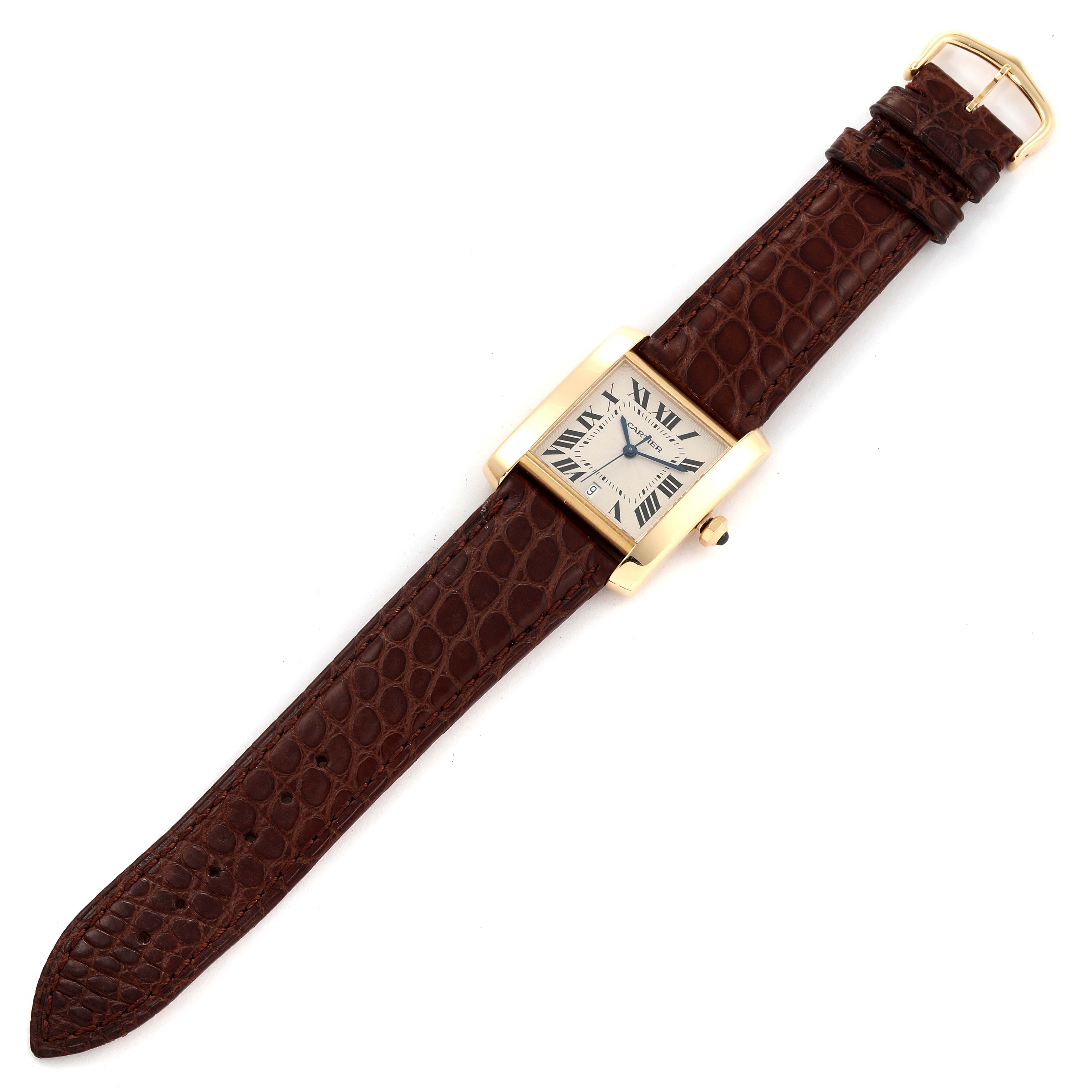 The Cartier Tank Française watch is shown from a top-down angle, displaying its face, bezel, and full leather strap.