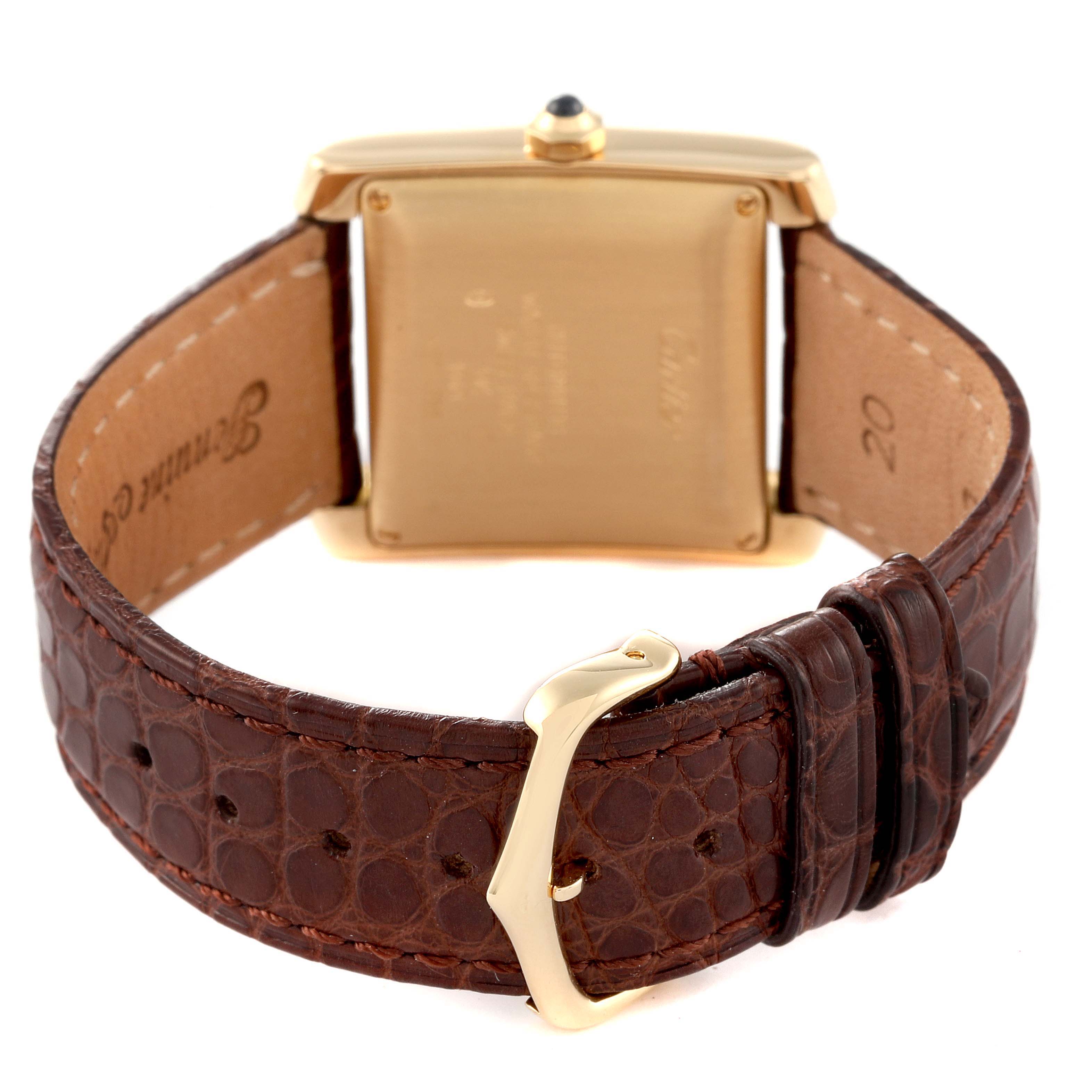 The image shows the back side of a Cartier Tank Française watch with a brown leather strap and gold buckle.