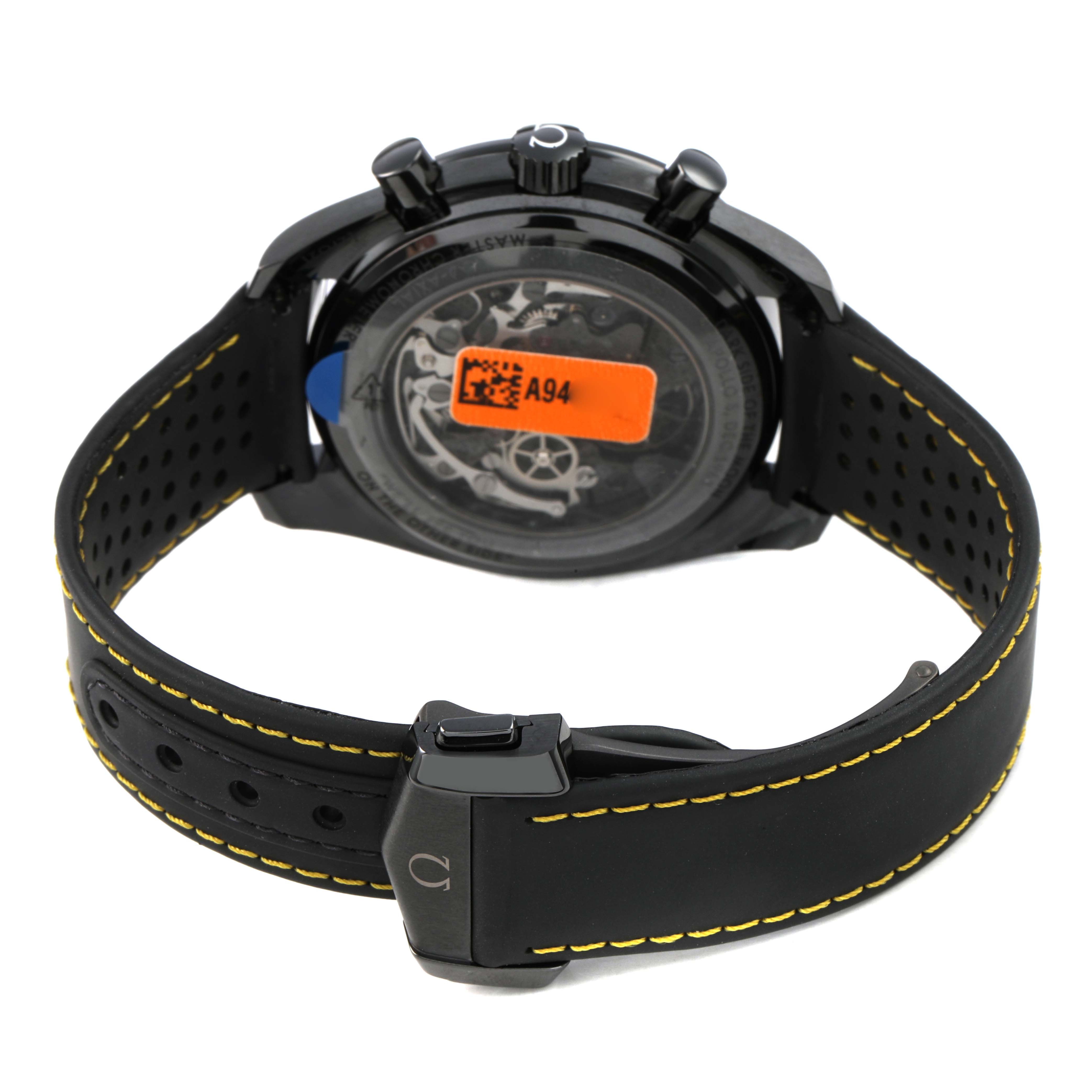 The Omega Speedmaster 310.92.44.50.01.001 Men's Ceramic Black Dial is shown from the back, highlighting its case back, pushers, and perforated strap with yellow stitching.