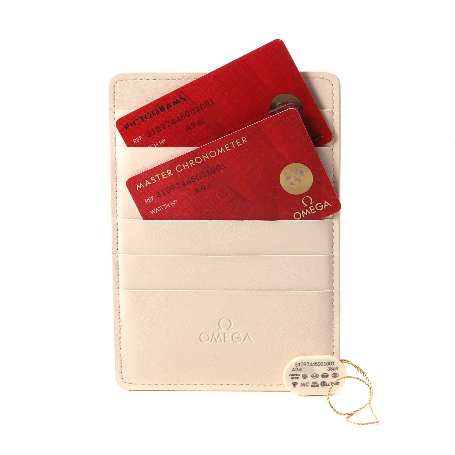The image shows Omega Speedmaster 310.92.44.50.01.001 Men's Ceramic Black Dial warranty cards and a tag in a cream-colored cardholder.