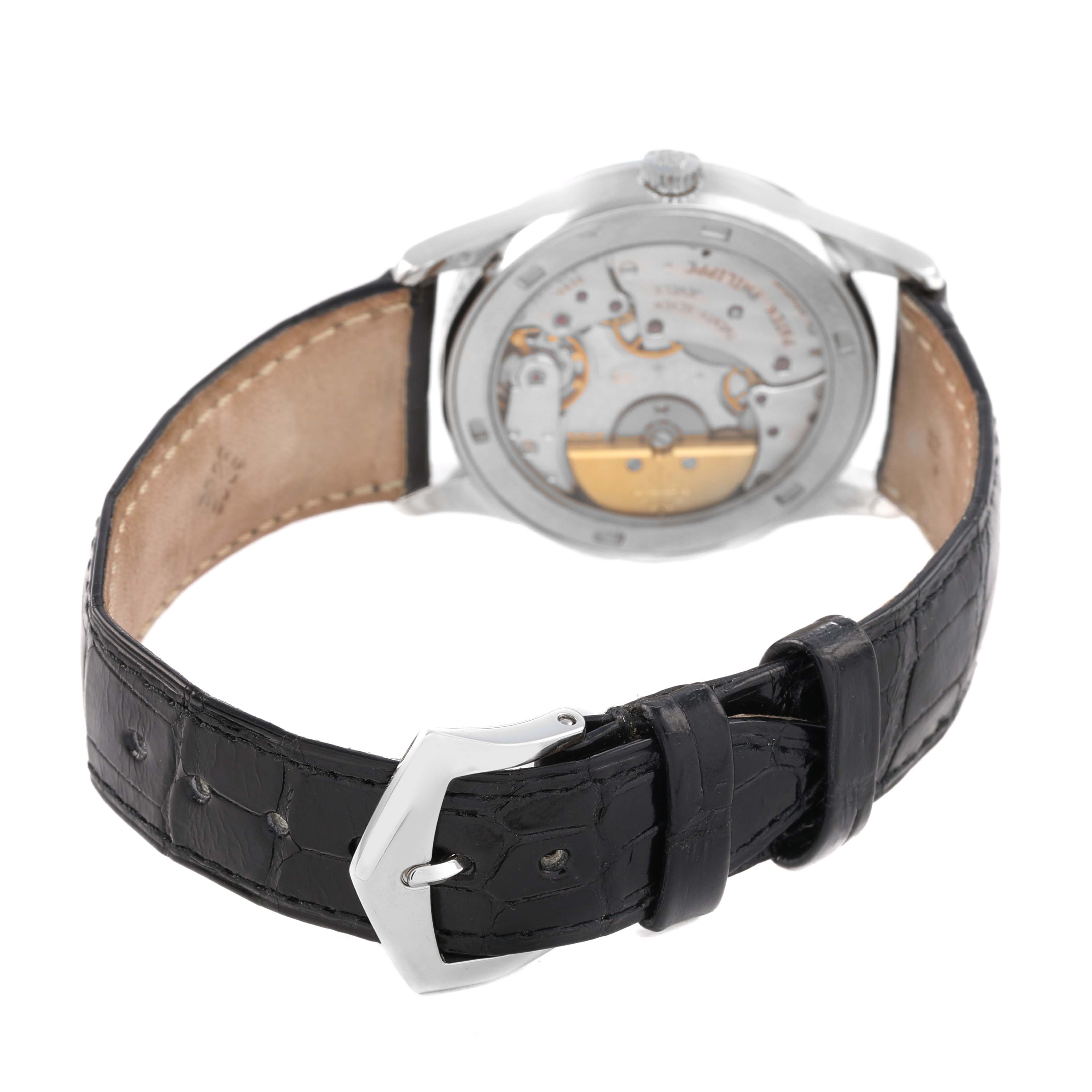 The Patek Philippe Calatrava 5026P-001 Men's Platinum Black Dial watch is shown from the back, displaying its movement through the transparent case back and its leather strap.